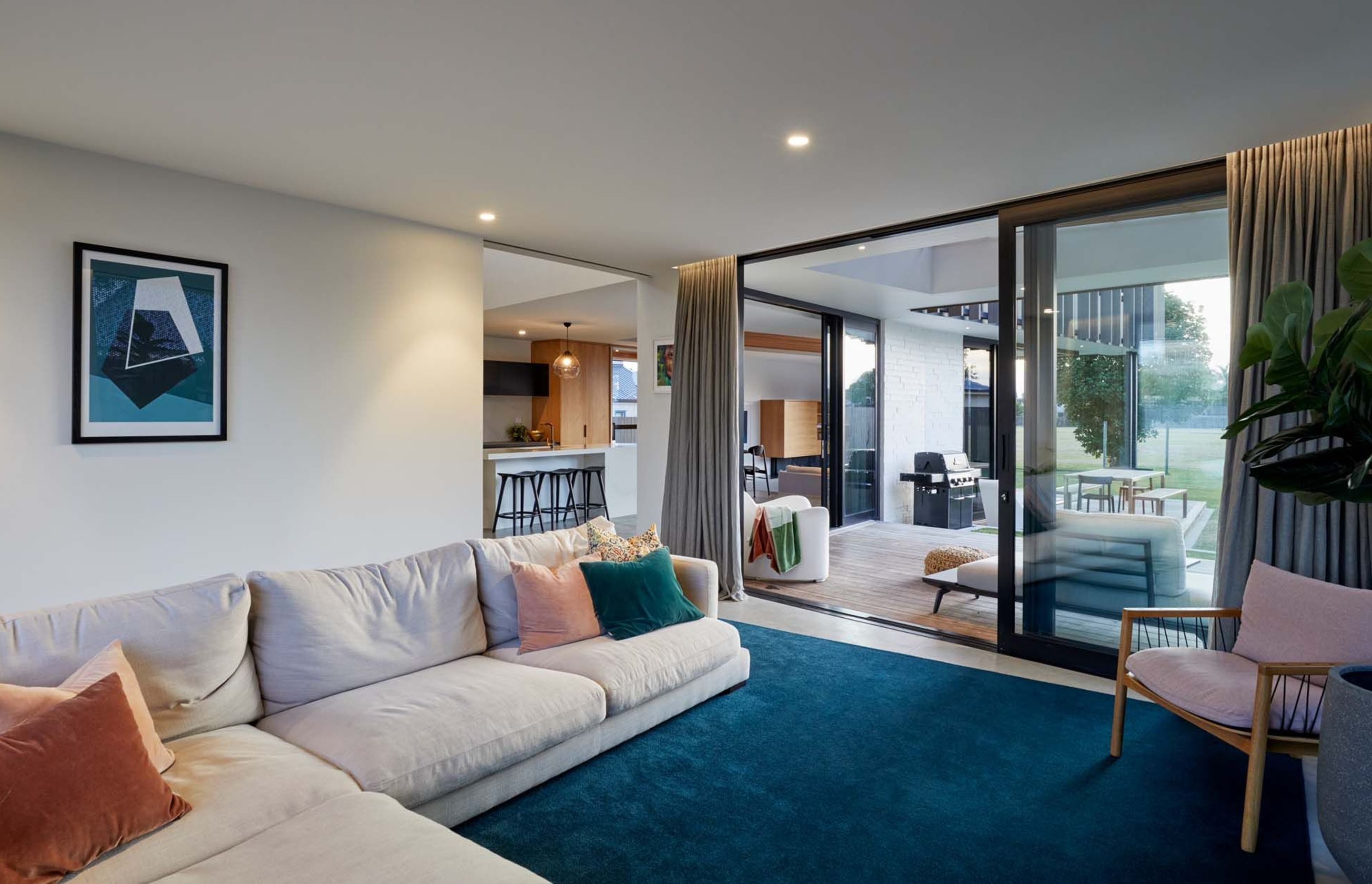 The lounge opens up to decks on either side, including a outdoor room with barbeque and dining table.