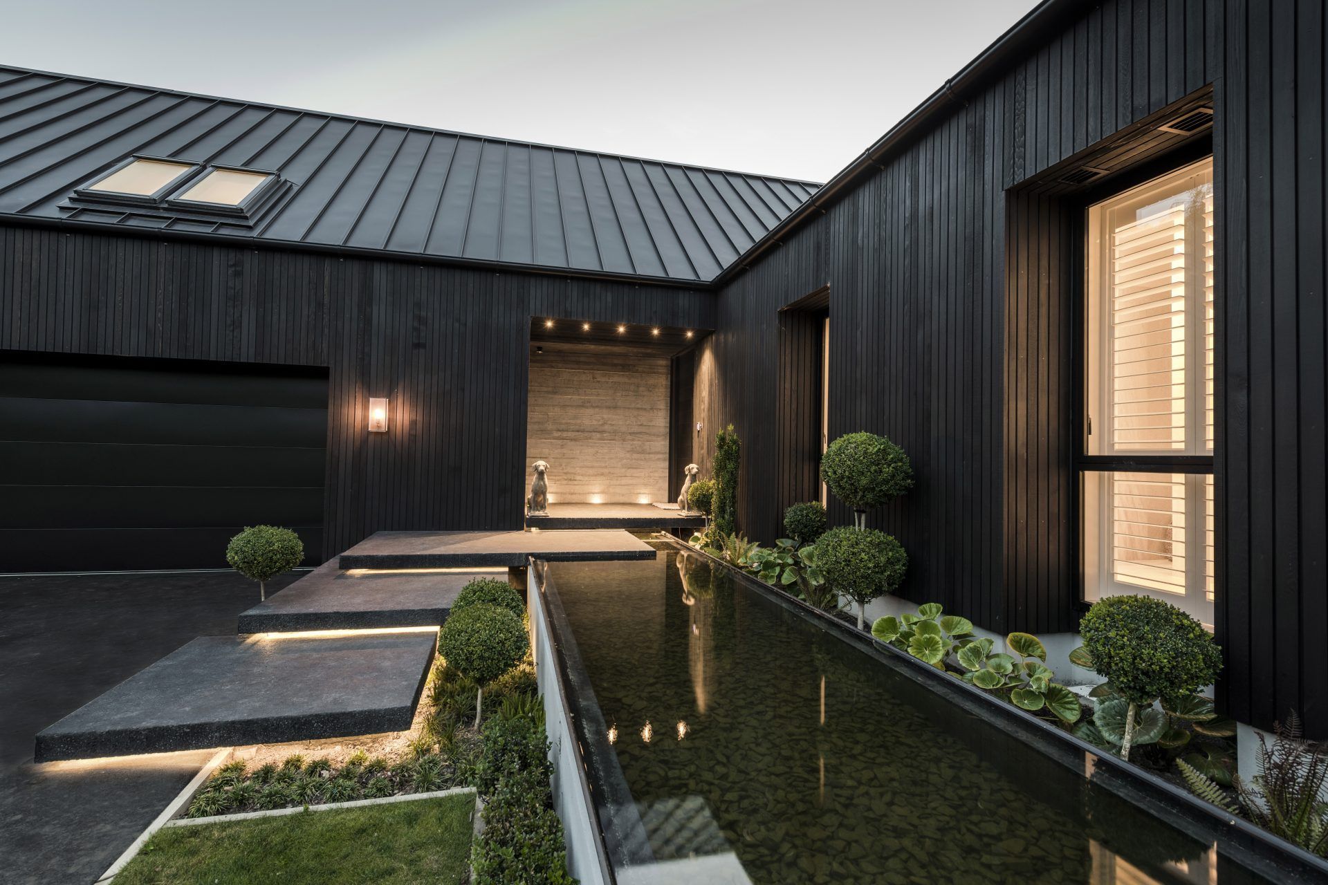 The front entrance creates a warm welcome for guests, with its reflective pool and floating steps that are underlit at night.