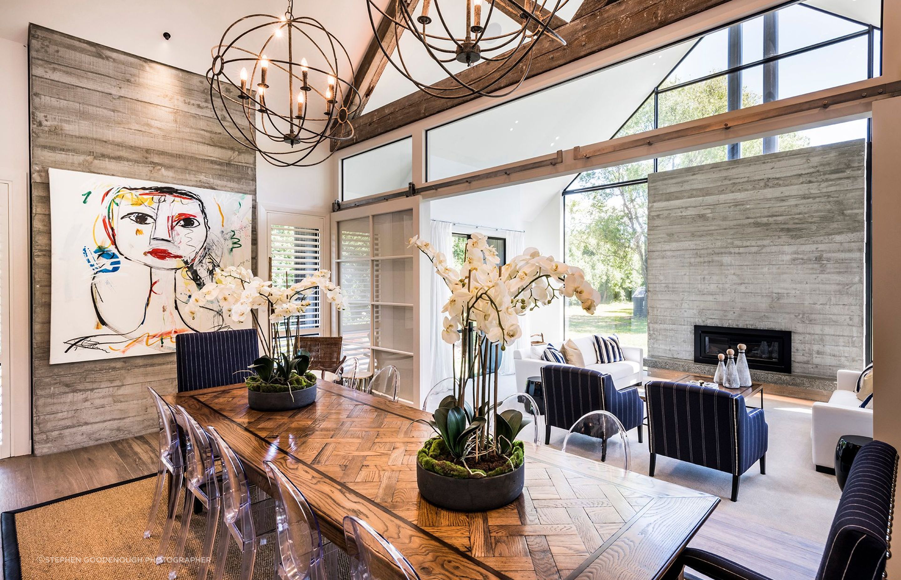 The dining area has an arty vibe, with paintings on the wall and a feature dining table with a parquet timber top.