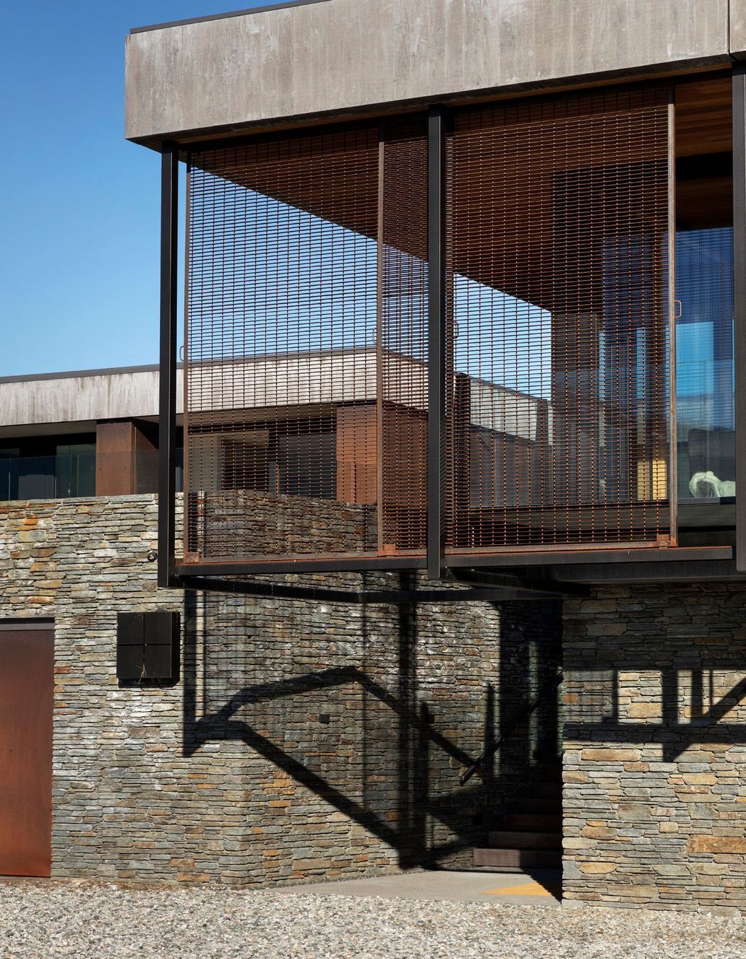 Rusty steel caging and schist stone take inspiration from buildings fo the region.