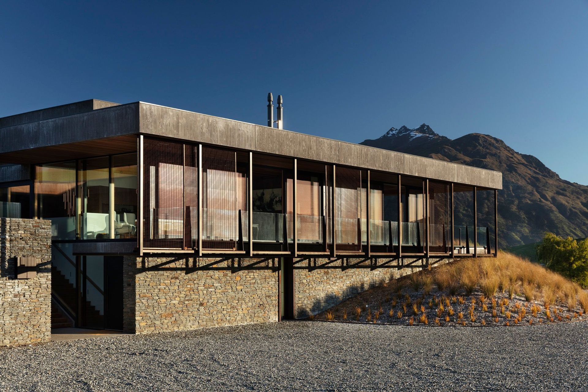 An exterior in natural schist stone, Corten steel and concrete helps to blend Oliver's RIdge into the surrounding landscape.