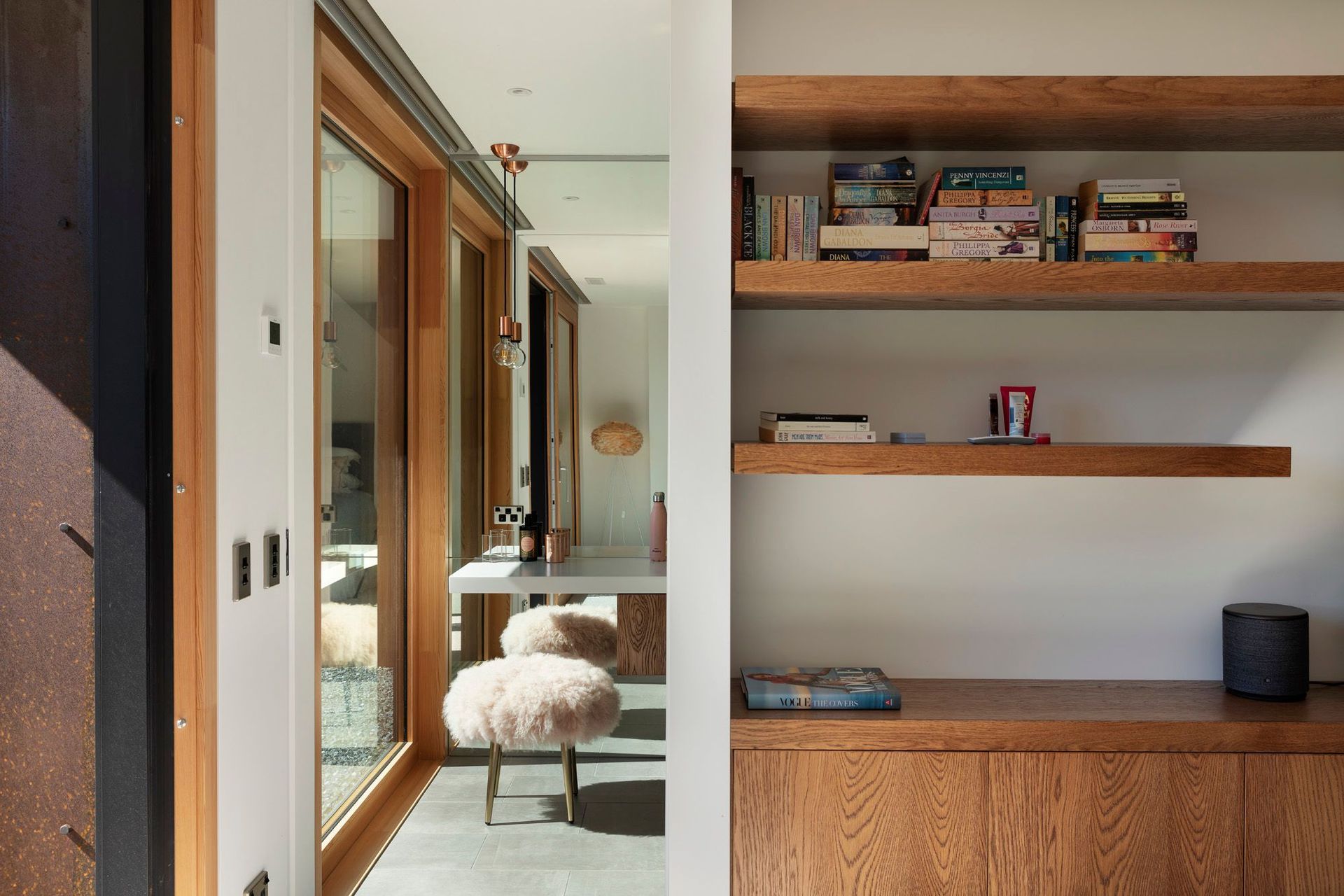 Oak shelving and oak cabinets divides this first-floor bedroom from its en suite bathroom.