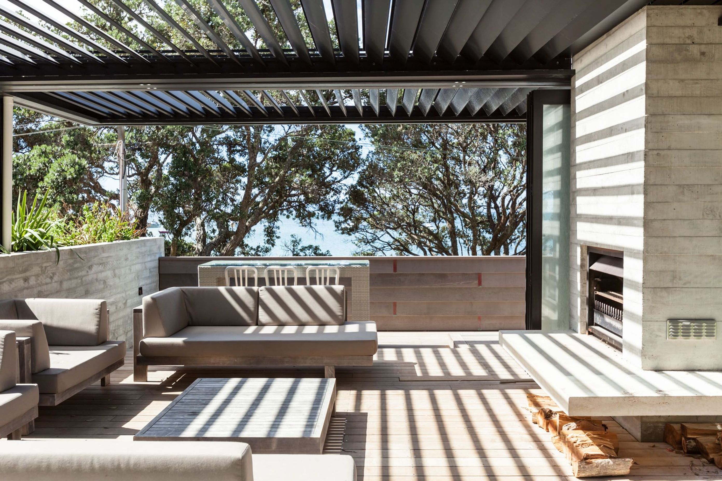 The organic black anodised finish on the RL200 louvres complements the weathered palette of the shuttered concrete and cedar  
