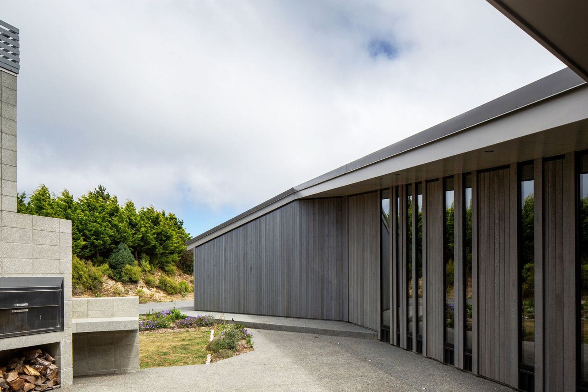 The courtyard is nestled into the 'U' of the plan and features an outdoor fireplace. The owner is currently making a table for this area from spotted gum leftover from the flooring.