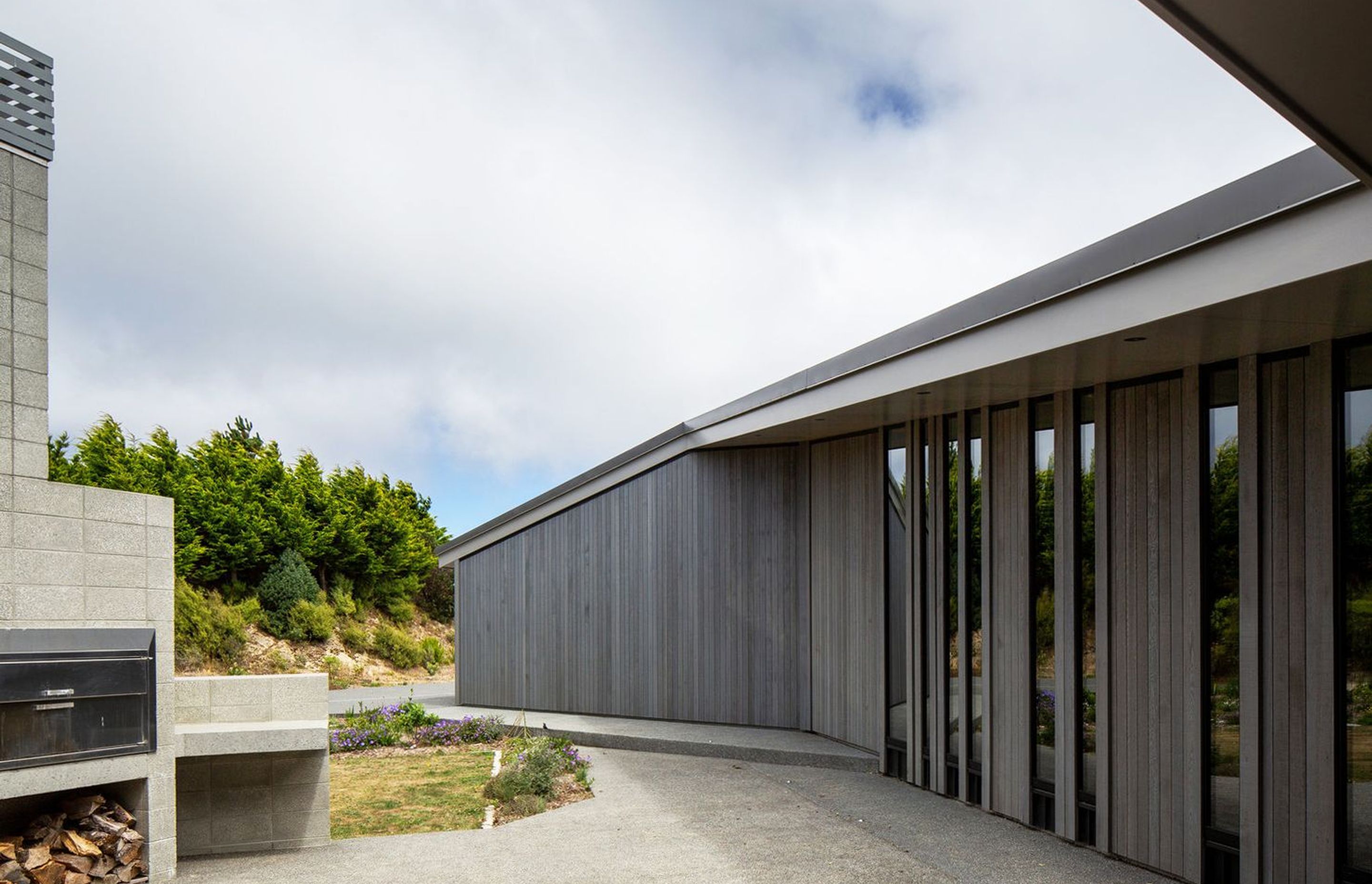 The courtyard is nestled into the 'U' of the plan and features an outdoor fireplace. The owner is currently making a table for this area from spotted gum leftover from the flooring.