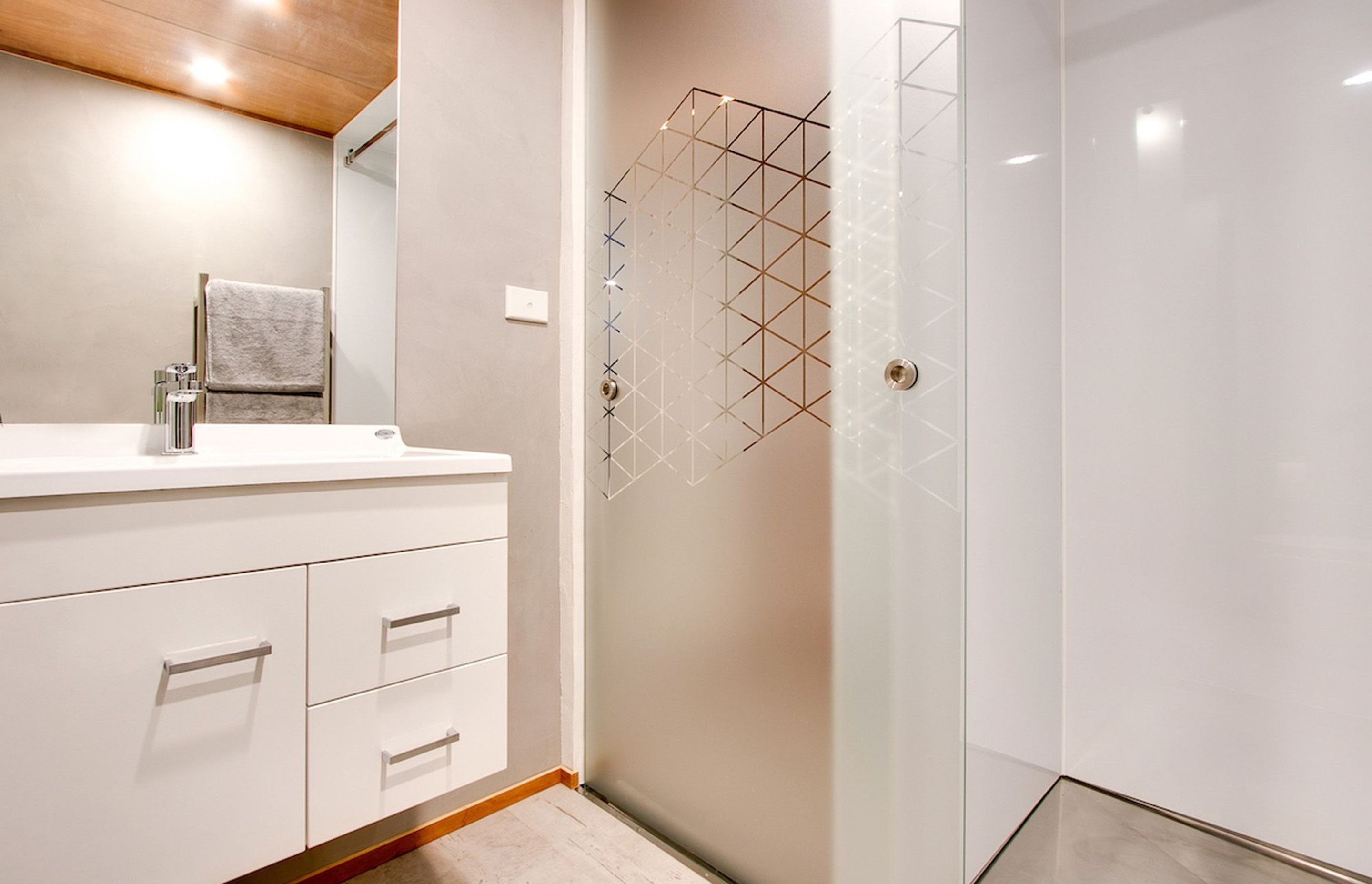 A geometric pattern is a feature on the shower door and window.