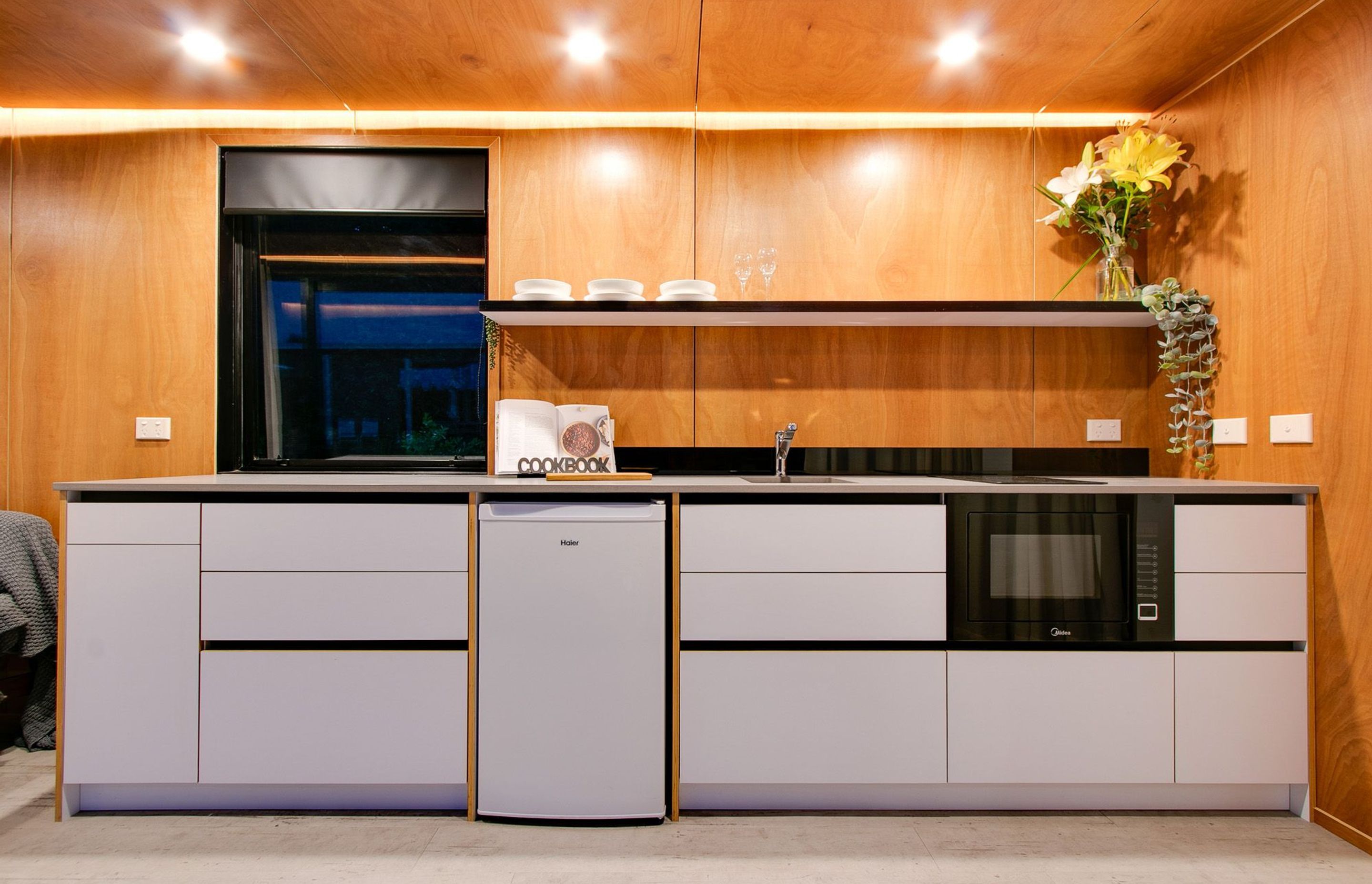 Plywood lines the walls and ceiling, combined with a white kitchen, ensures a minimal look.