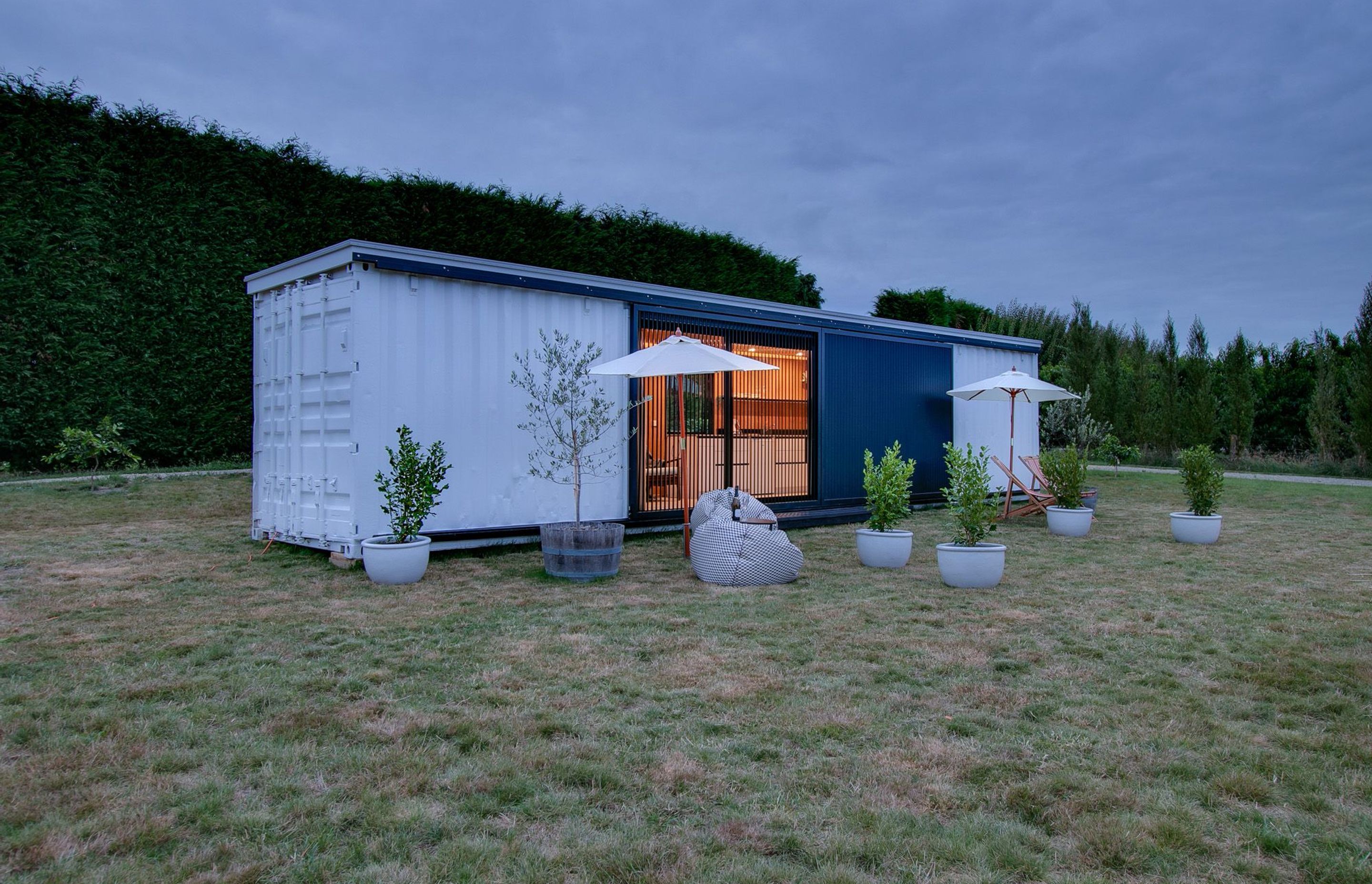 Planted trees, pot plants and outdoor furniture help to make the container dwelling more like a home.