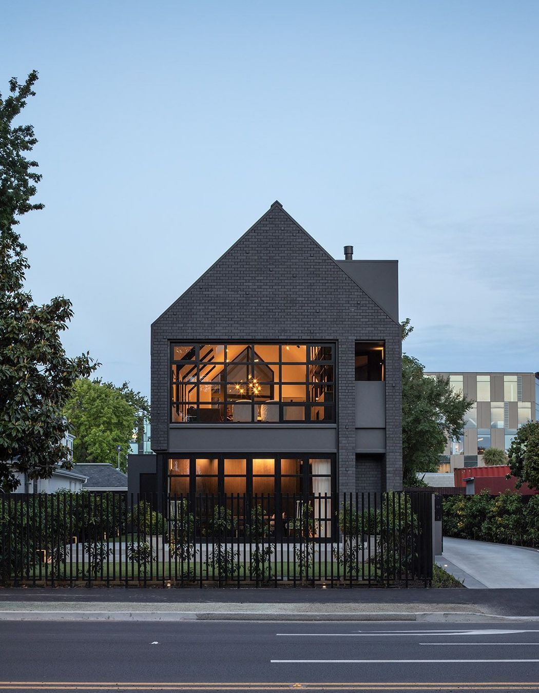 In the front garden, a simple paved patio looks directly across to the willows of Hagley Park.