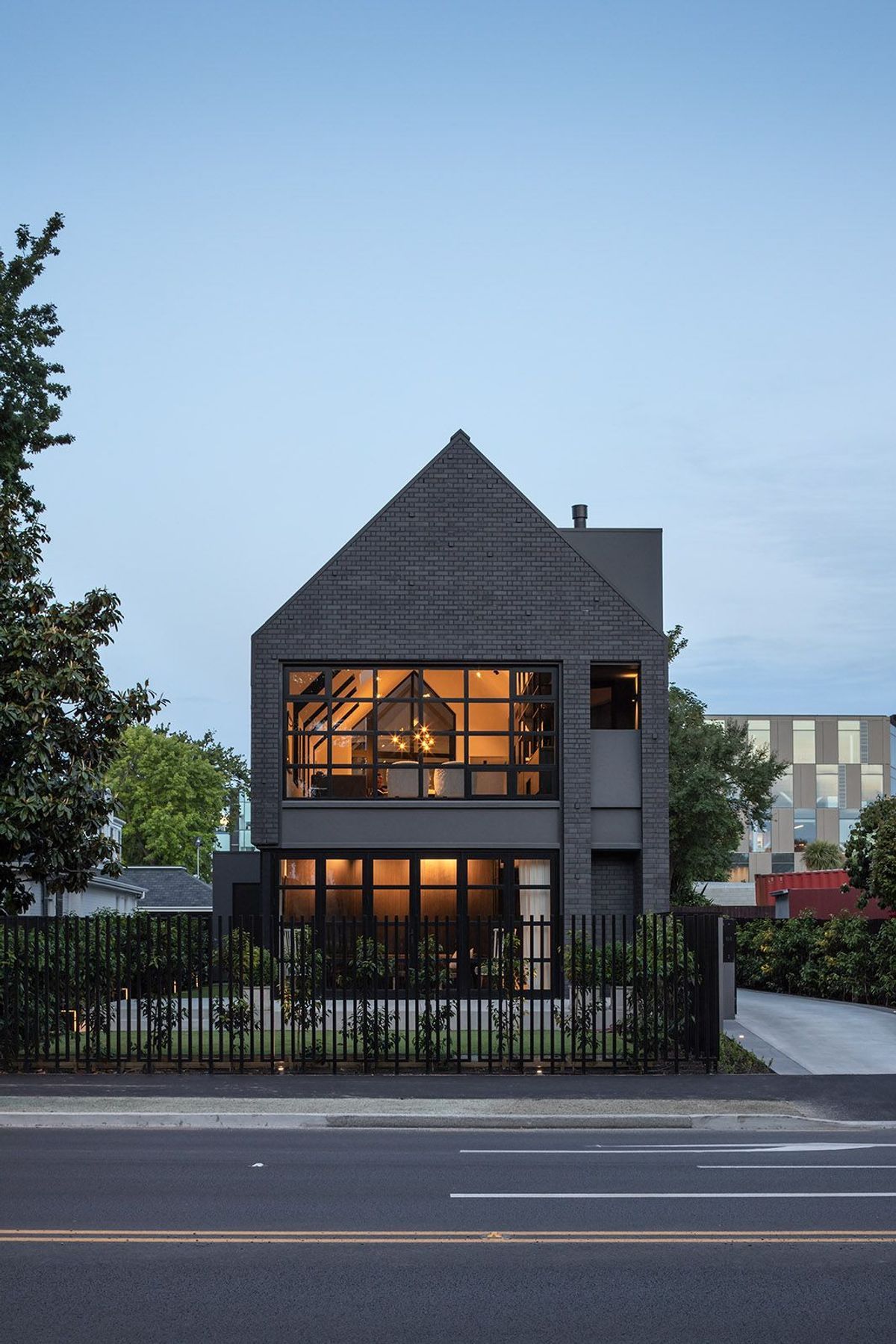 In the front garden, a simple paved patio looks directly across to the willows of Hagley Park.