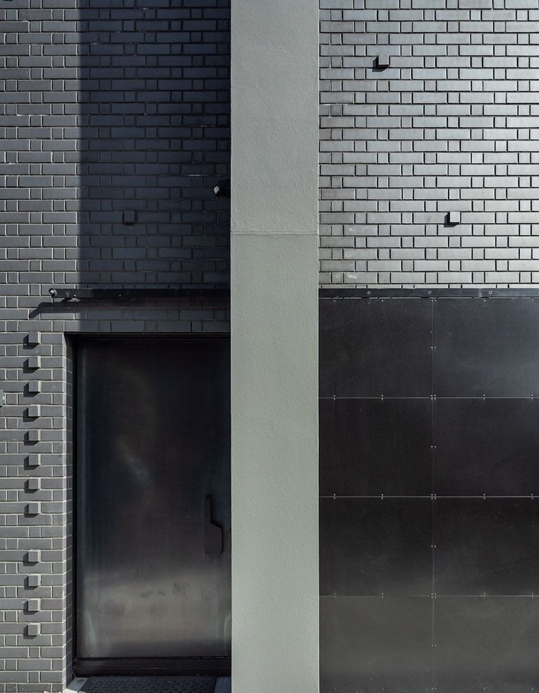 Here, the hot-rolled steel entry door is tucked away behind a bespoke hot rolled steel barn-style door; an entrance that gives little away.