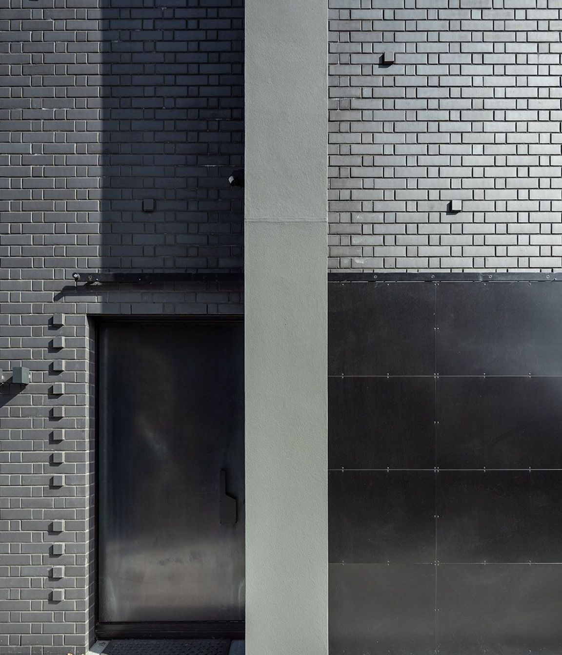 Here, the hot-rolled steel entry door is tucked away behind a bespoke hot rolled steel barn-style door; an entrance that gives little away.