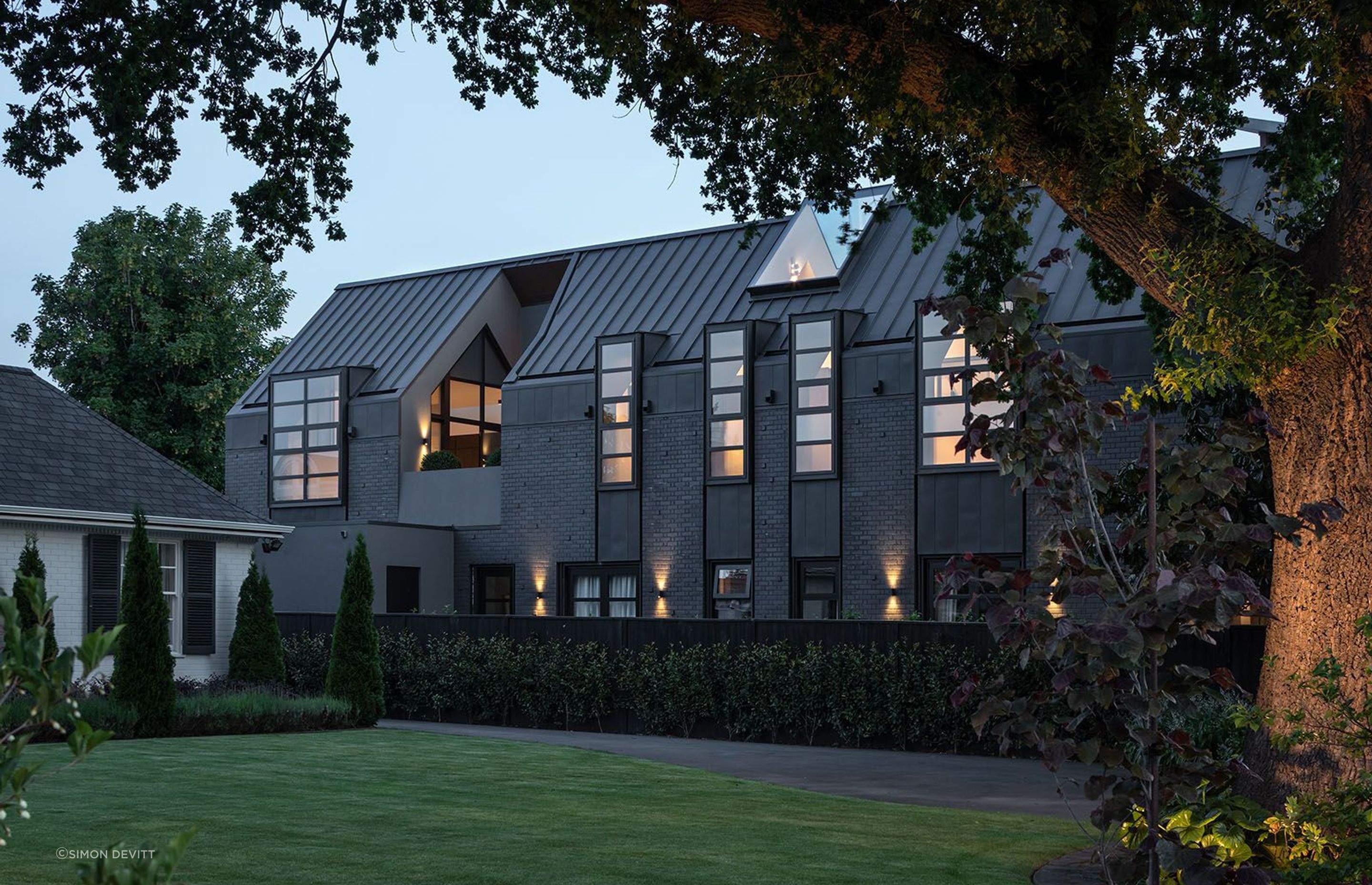 Under the cloak of darkness, the home is lofty and light, its interiors turning outwards, floating weightlessly atop a shrouded form. A courtyard is carved out of the gabled form, separating the open-plan area from the intimate areas of the upper level,