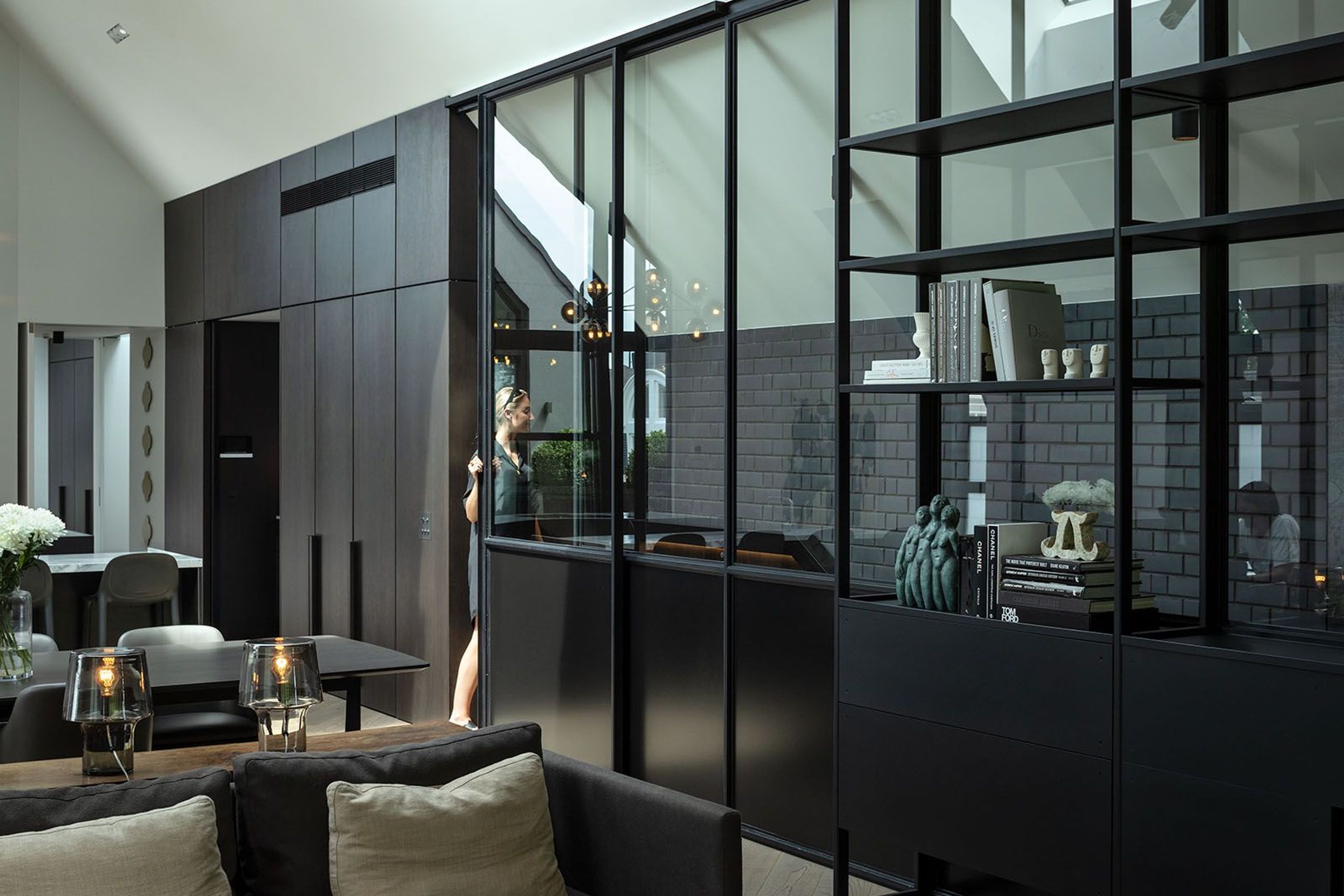 Reaching the top of the stairs, the language changes. Here, the palette offers a boldness where white prevails, juxtaposed with the rich black of the brick, steel and dark features throughout the room.