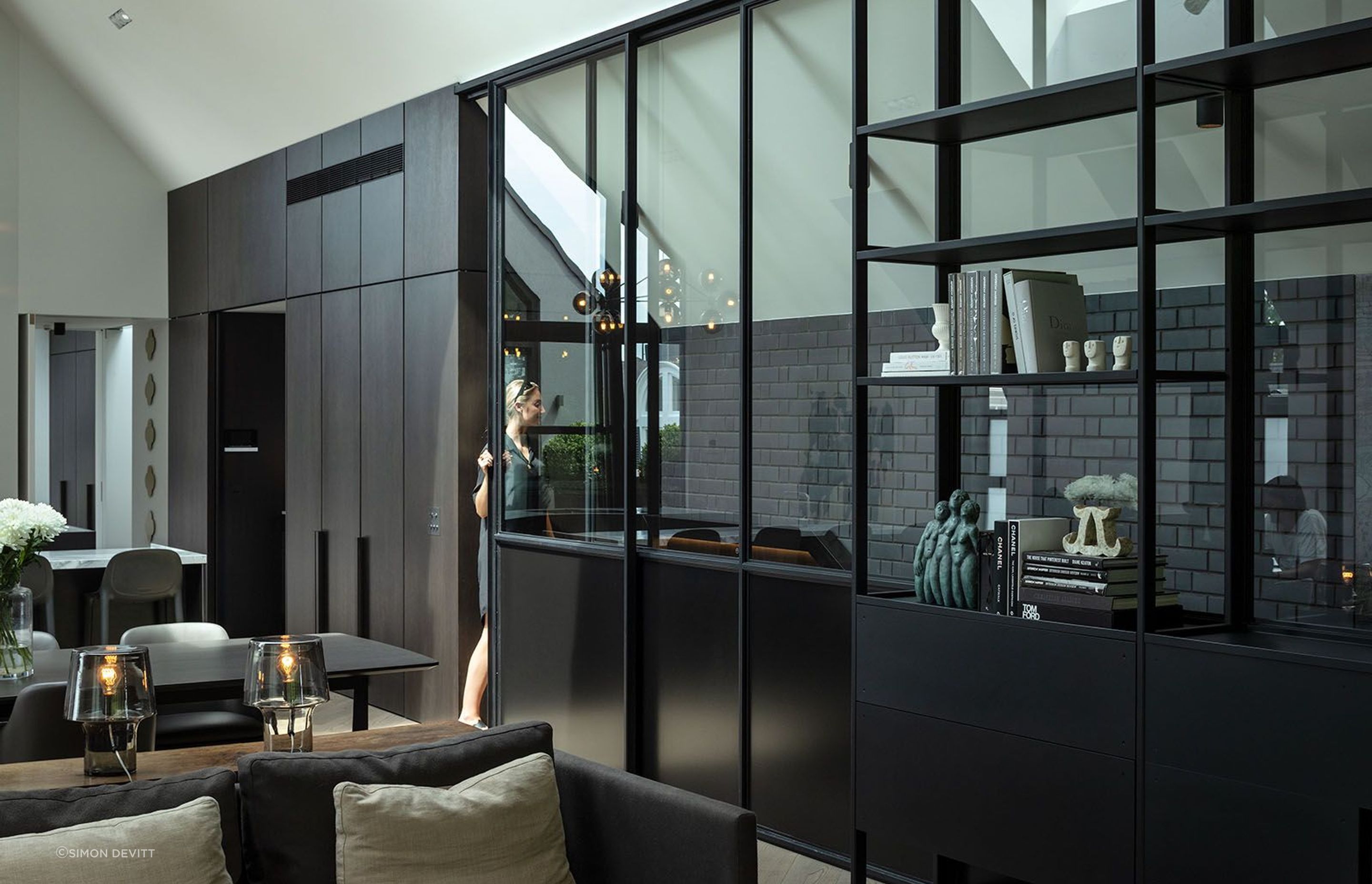 Reaching the top of the stairs, the language changes. Here, the palette offers a boldness where white prevails, juxtaposed with the rich black of the brick, steel and dark features throughout the room.