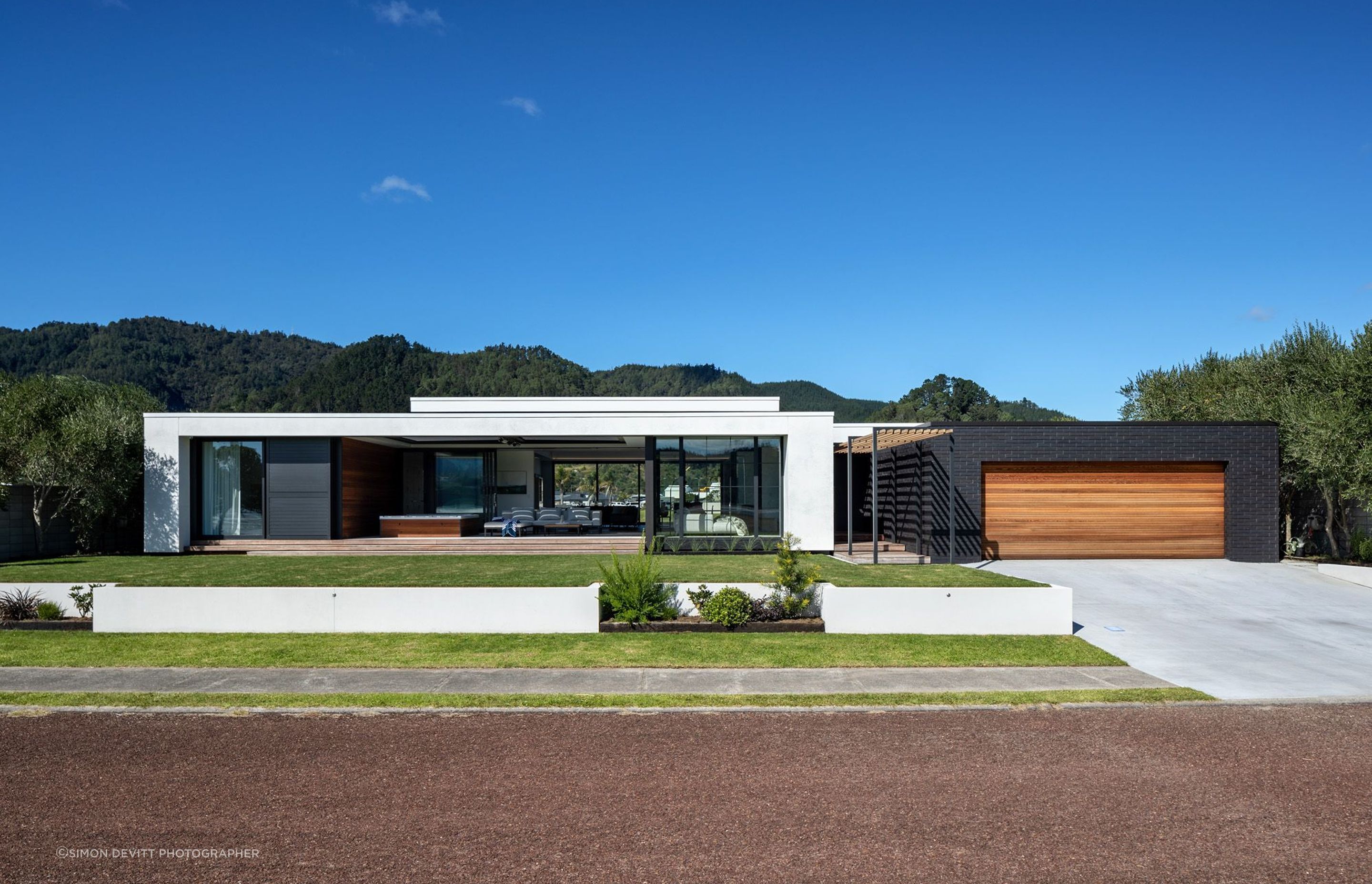 The view from the street shows the clean lines of the pavilion form with its contrasting materials defining the house from the garage.