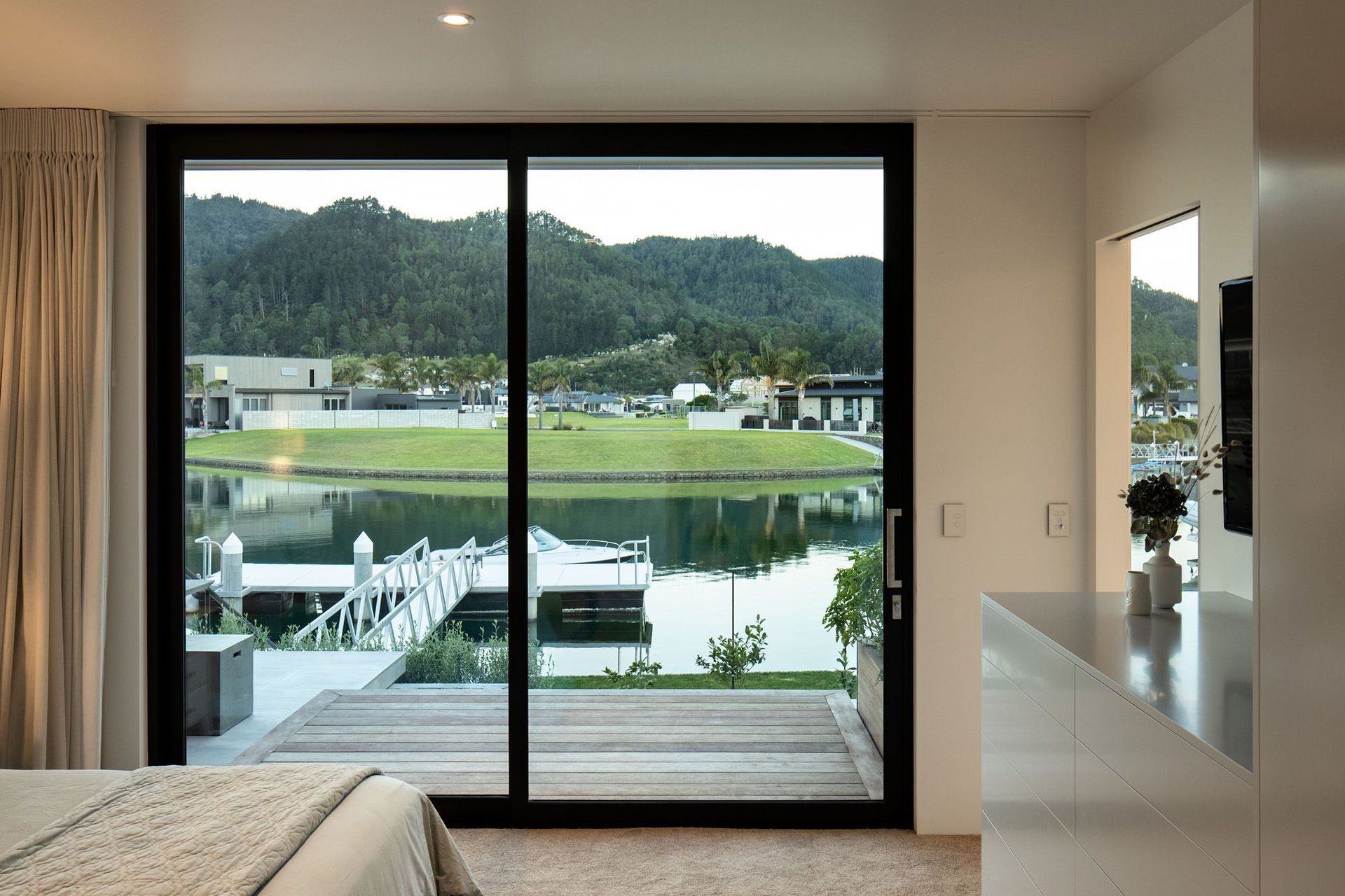 This master bedroom has a floor-to-ceiling view of the boat dock.