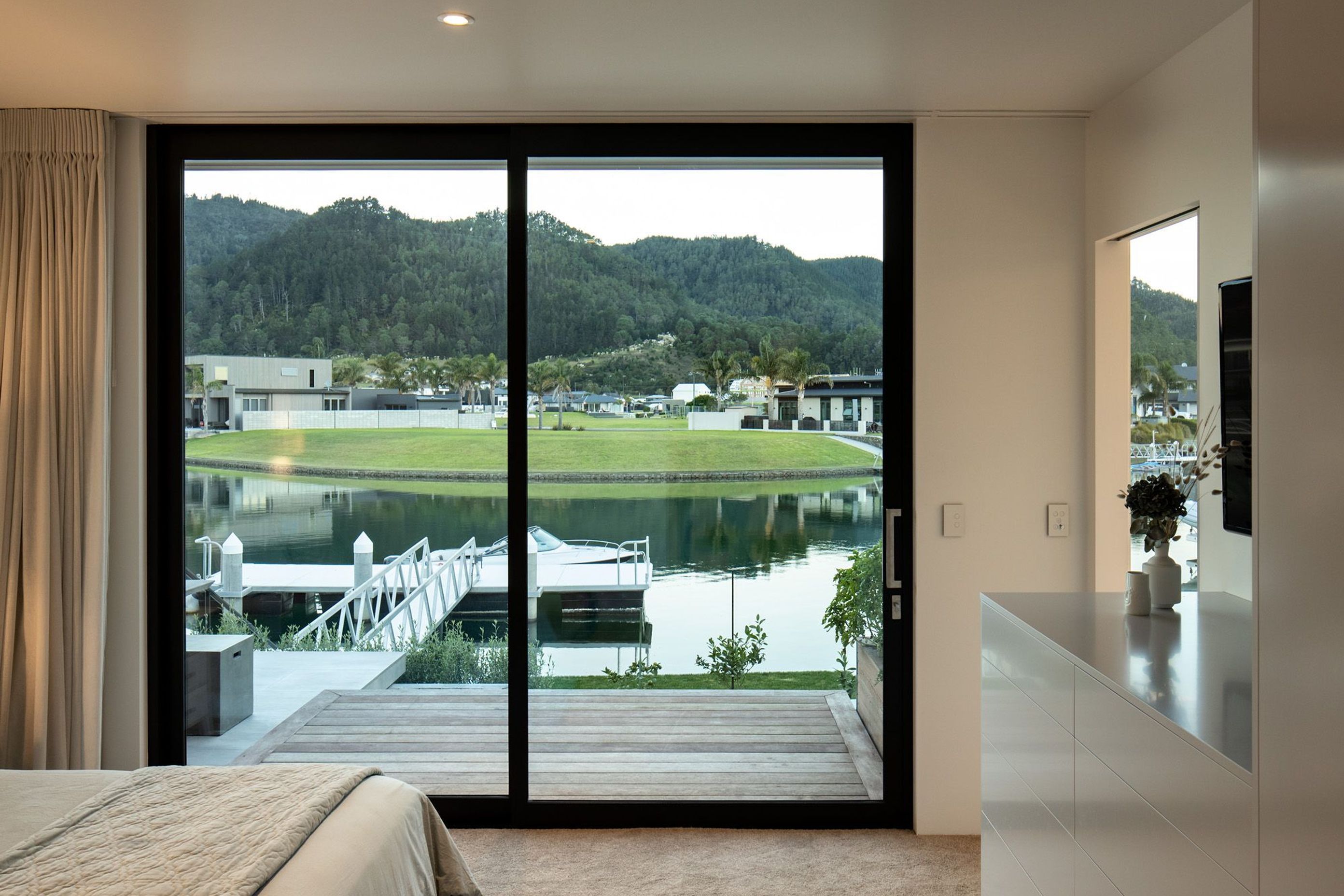 This master bedroom has a floor-to-ceiling view of the boat dock.