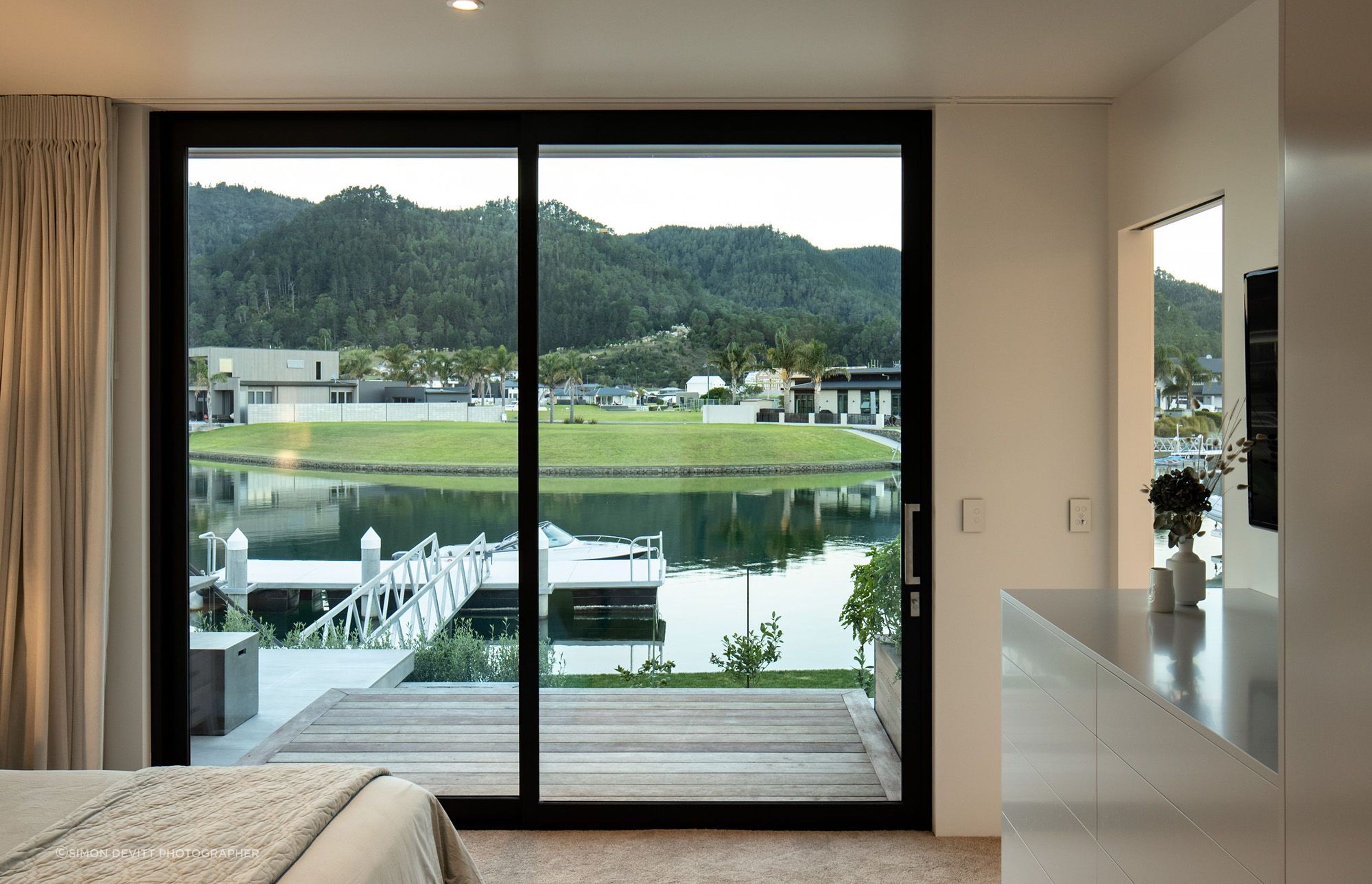 This master bedroom has a floor-to-ceiling view of the boat dock.