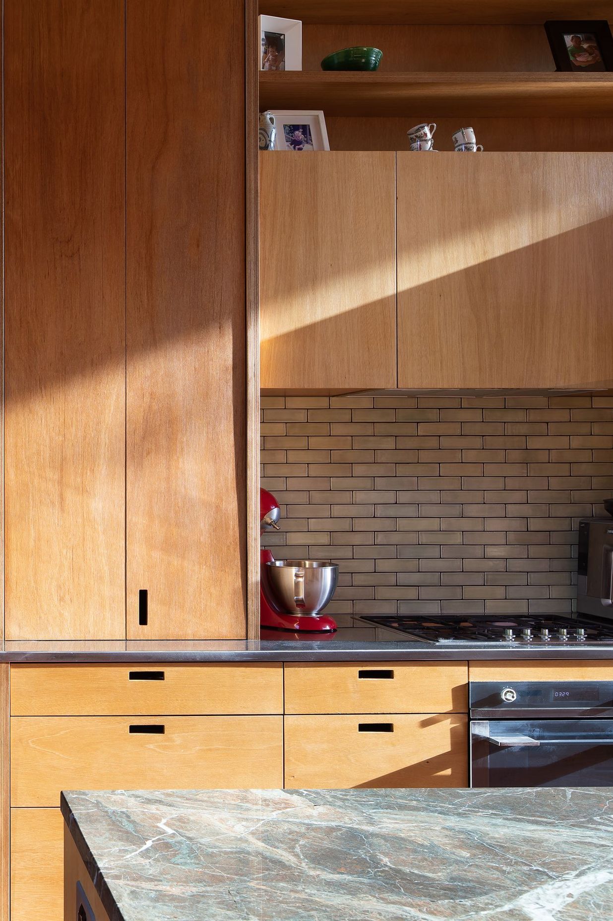 A close-up of the kitchen reveals the bespoke locally built plywood cabinetry.