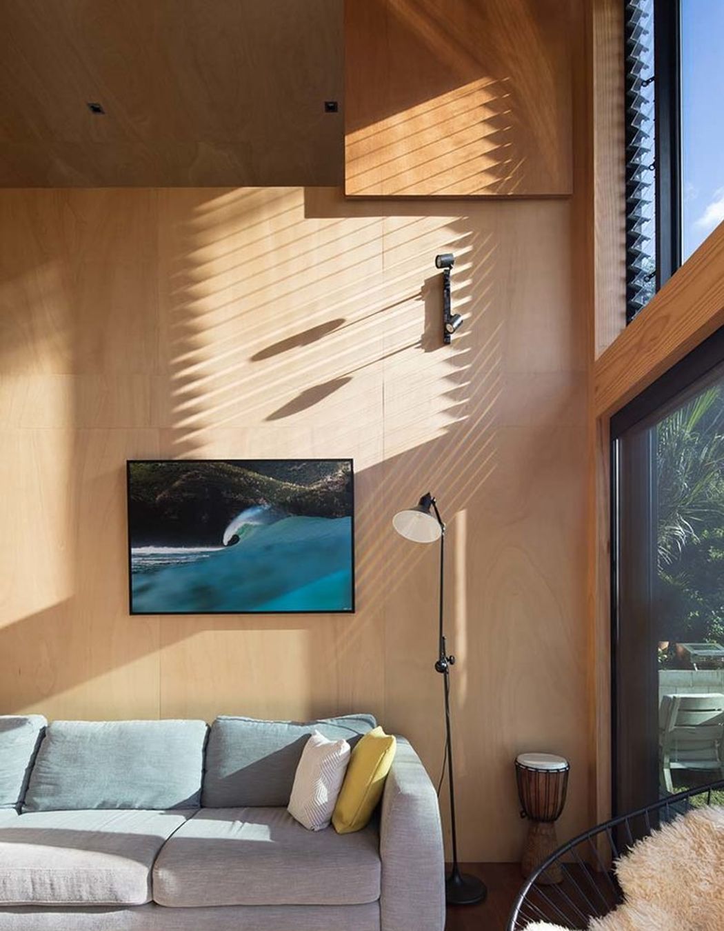 Mid-to-late afternoon sun provides warmth and light due to the large window areas.<br />Framed Piha wave photograph by Craig Levers.