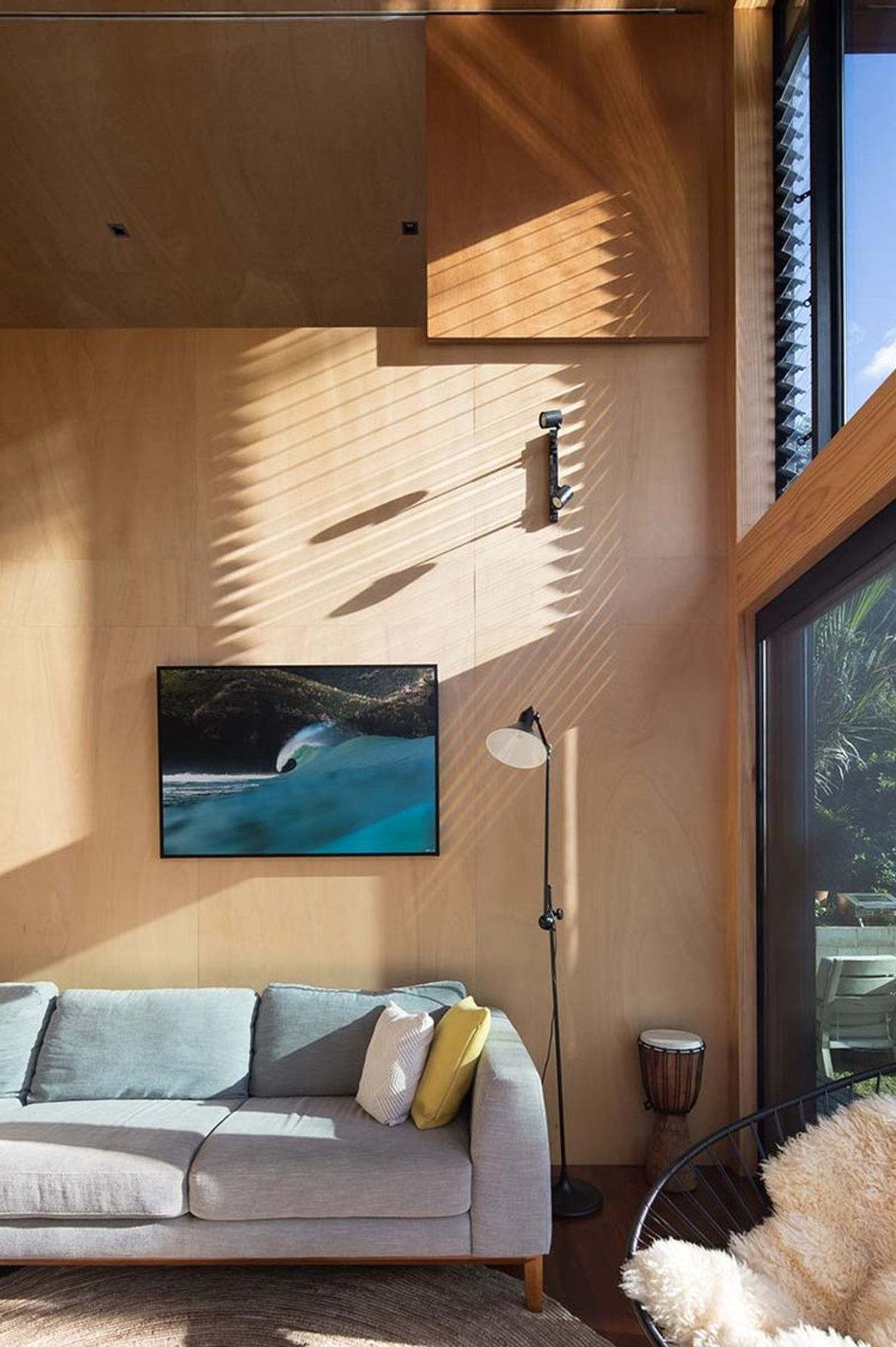 Mid-to-late afternoon sun provides warmth and light due to the large window areas.<br />Framed Piha wave photograph by Craig Levers.