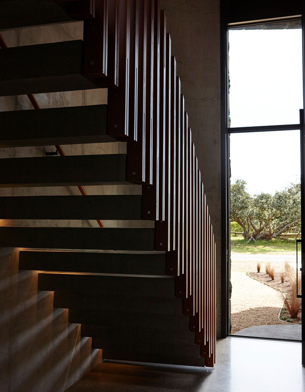 The cantilevered staircase mimics the first floor that juts out over the entry, establishing the interior as an arrangement of complex forms.