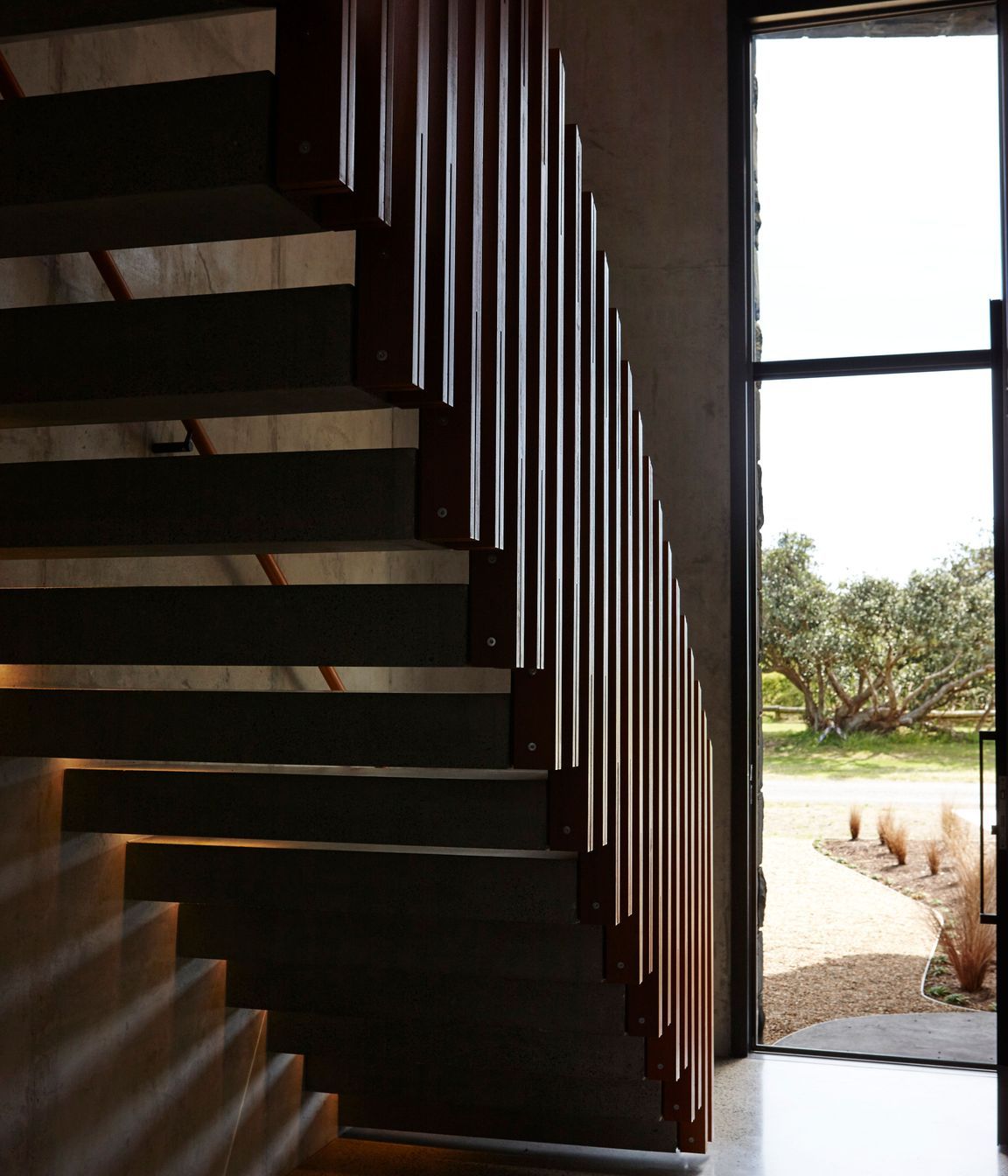 The cantilevered staircase mimics the first floor that juts out over the entry, establishing the interior as an arrangement of complex forms.