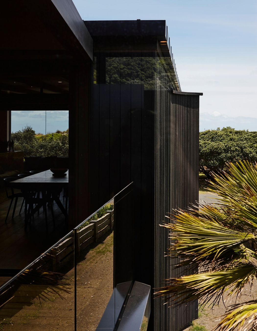 With living areas confined to the first floor, outdoor spaces read like niches within the building's envelope. Floor-to-ceiling glazing facilitates clear sightlines to the view beyond.