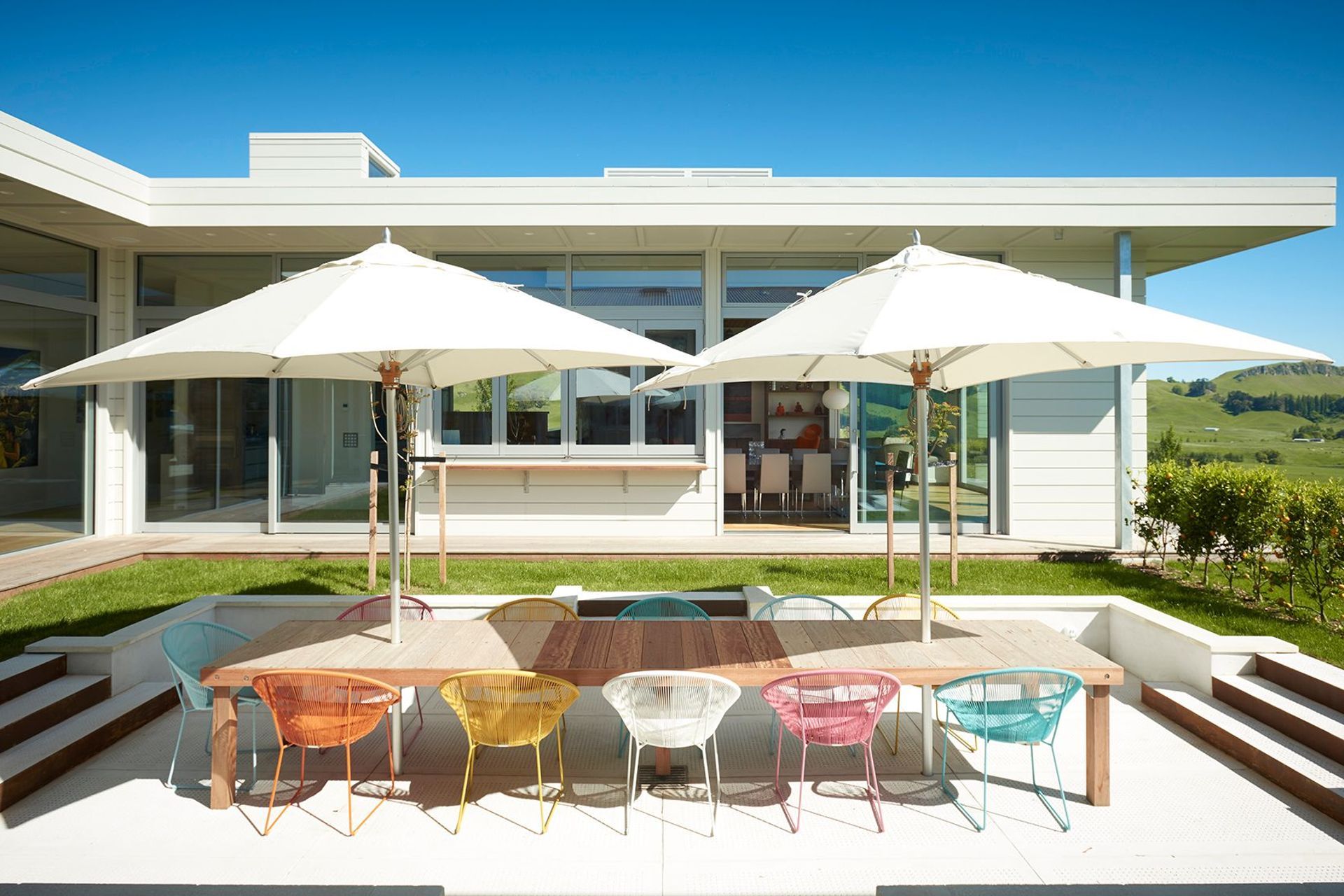 Looking across from the bedroom wing to the sunken outdoor dining area and the open-plan living and dining area opposite.