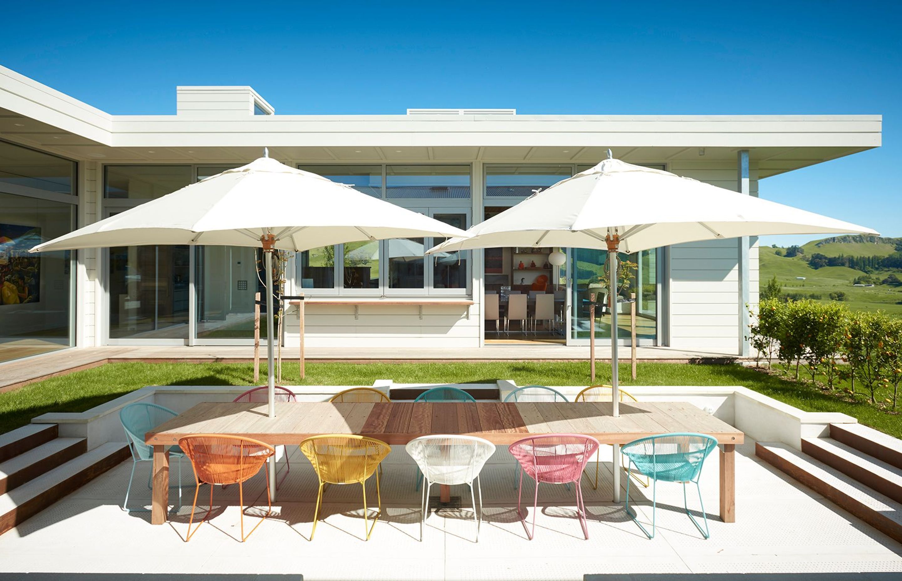 Looking across from the bedroom wing to the sunken outdoor dining area and the open-plan living and dining area opposite.