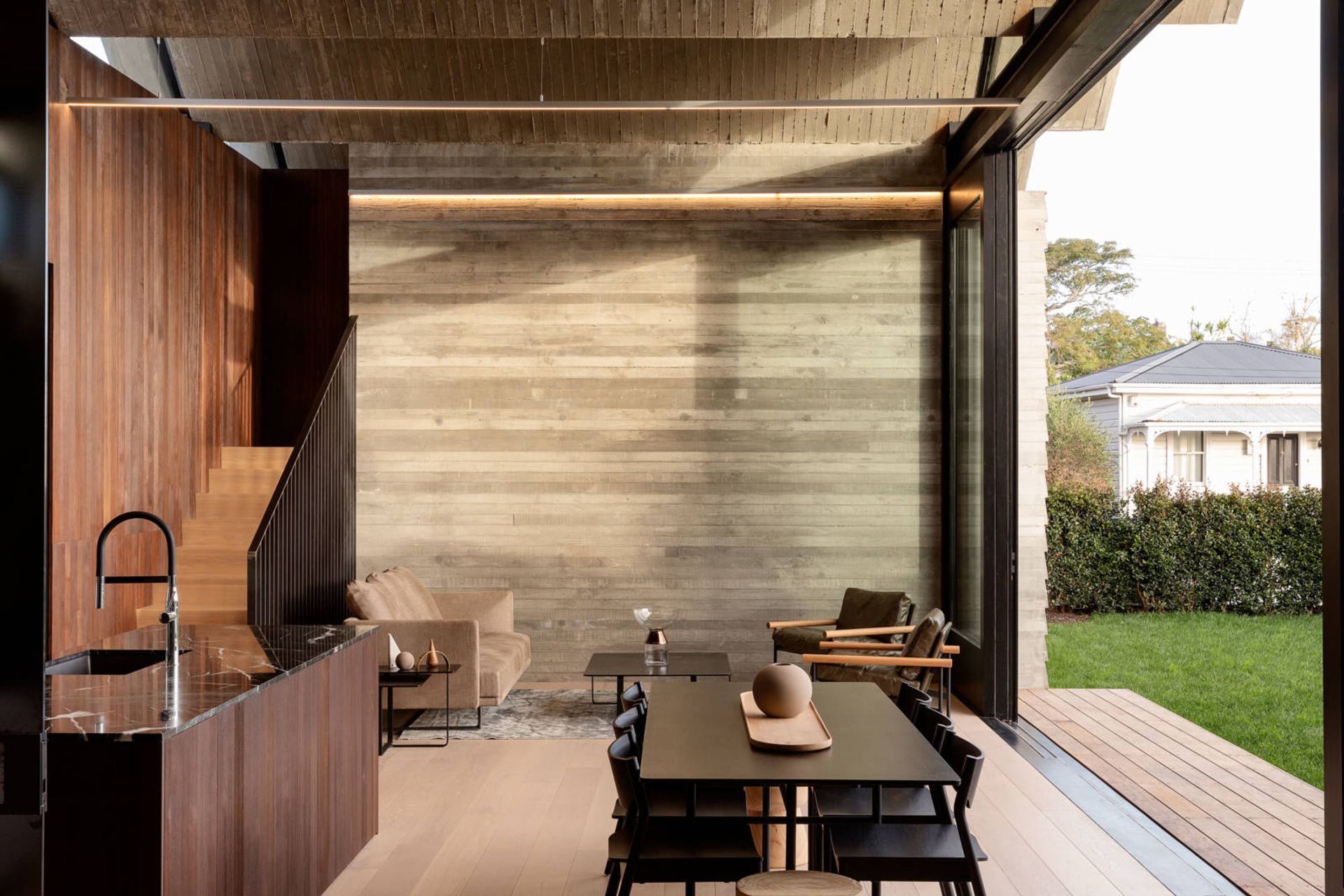 New and old – a neighbouring villa is juxtaposed against the new Poured Pleats structure, but the horizontal weatherboard pattern in the concrete helps to marry the two buildings.