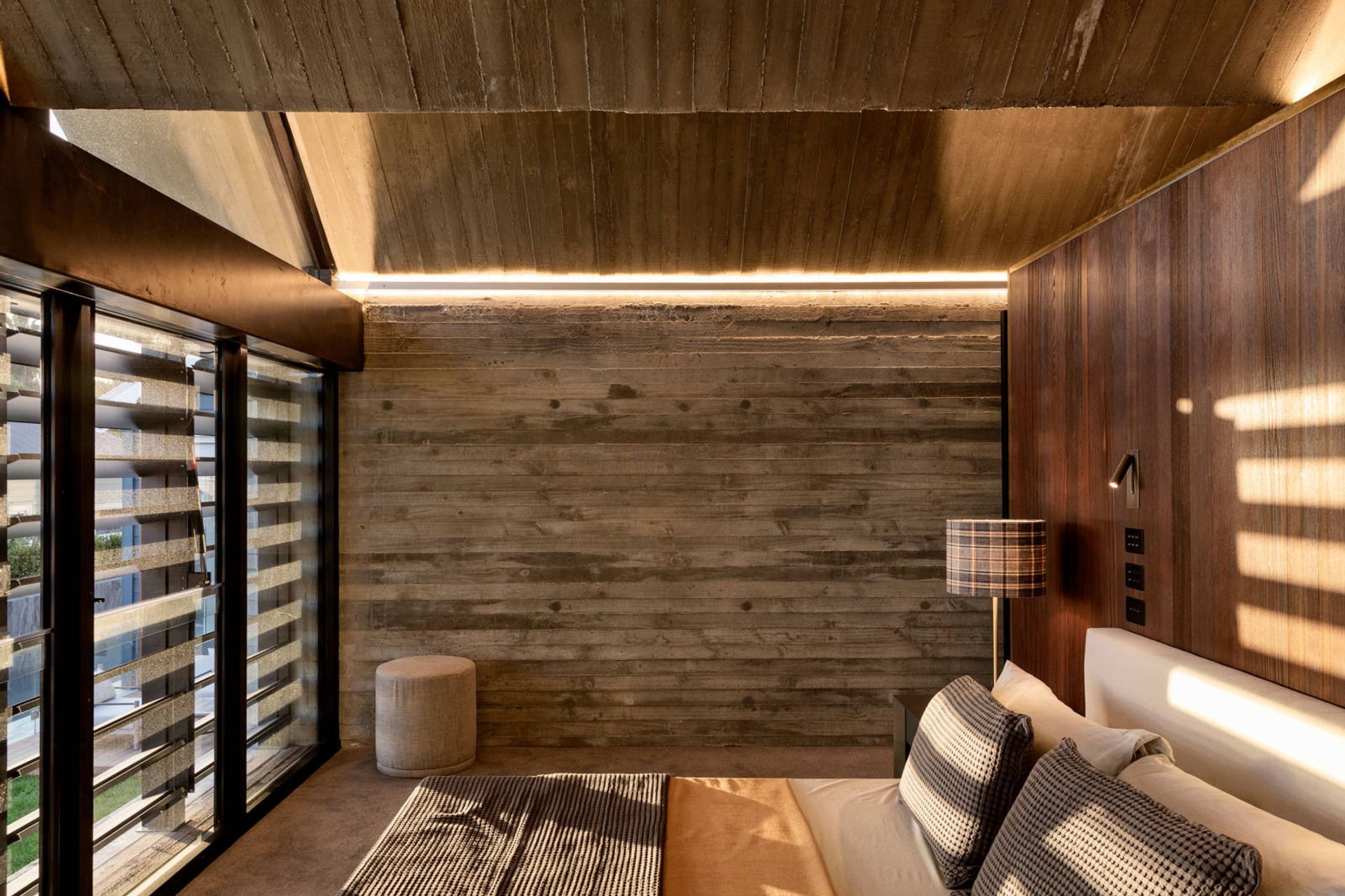 The guest suite enjoys the striking zigzag concrete ceiling, along with walls in weatherboard-shuttere concrete and timber panelling.
