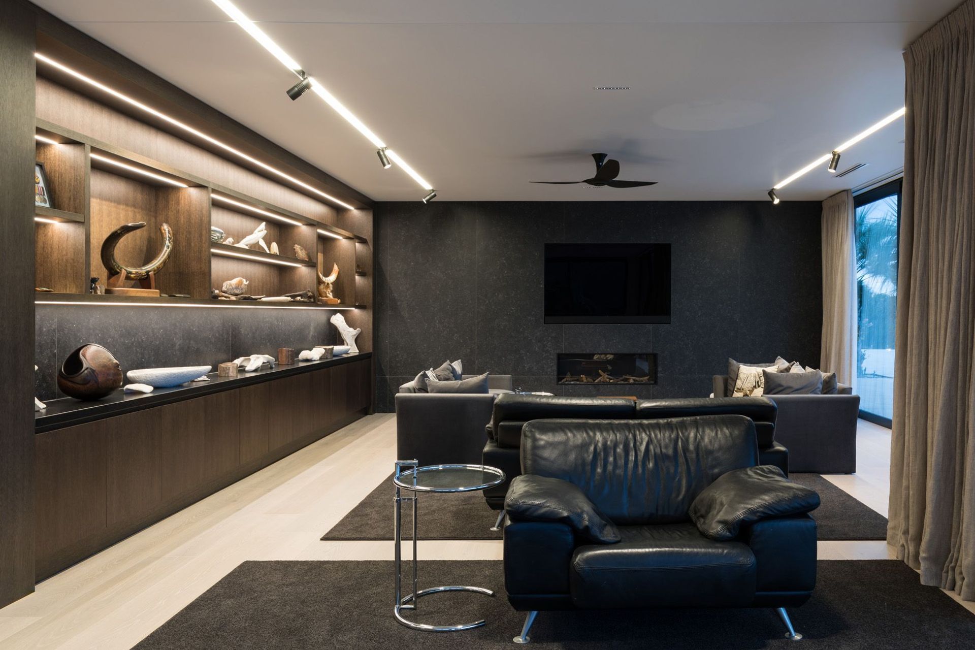 The lounge enjoys cosy fireside seating and views out over Houhora Harbour. LED strip lights add a touch of drama to the ceiling and cabinetry in the evening.