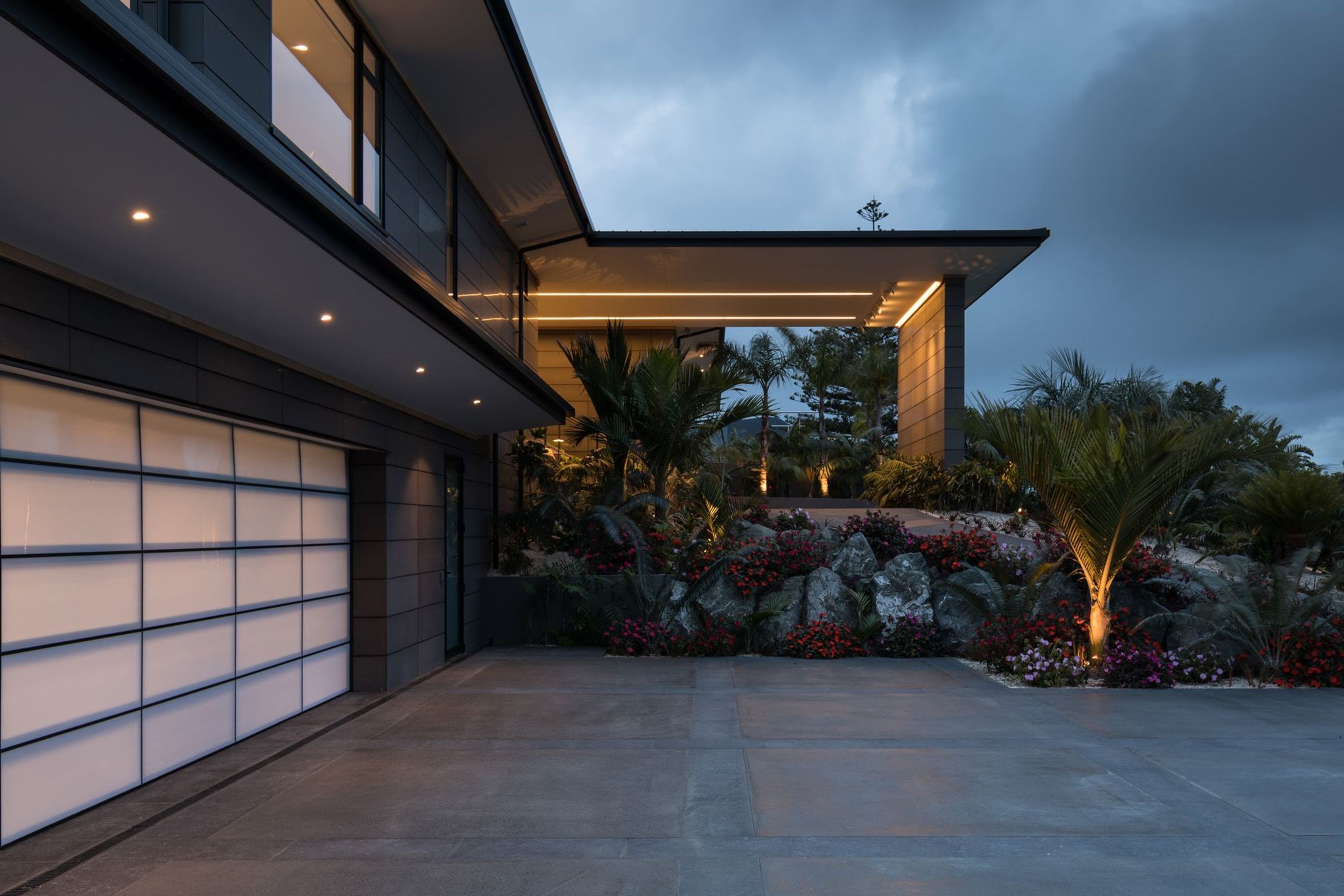 A portico juts out from the side of the first-floor level, providing shelter at the main entrance, much like you mgiht find at a luxury hotel.