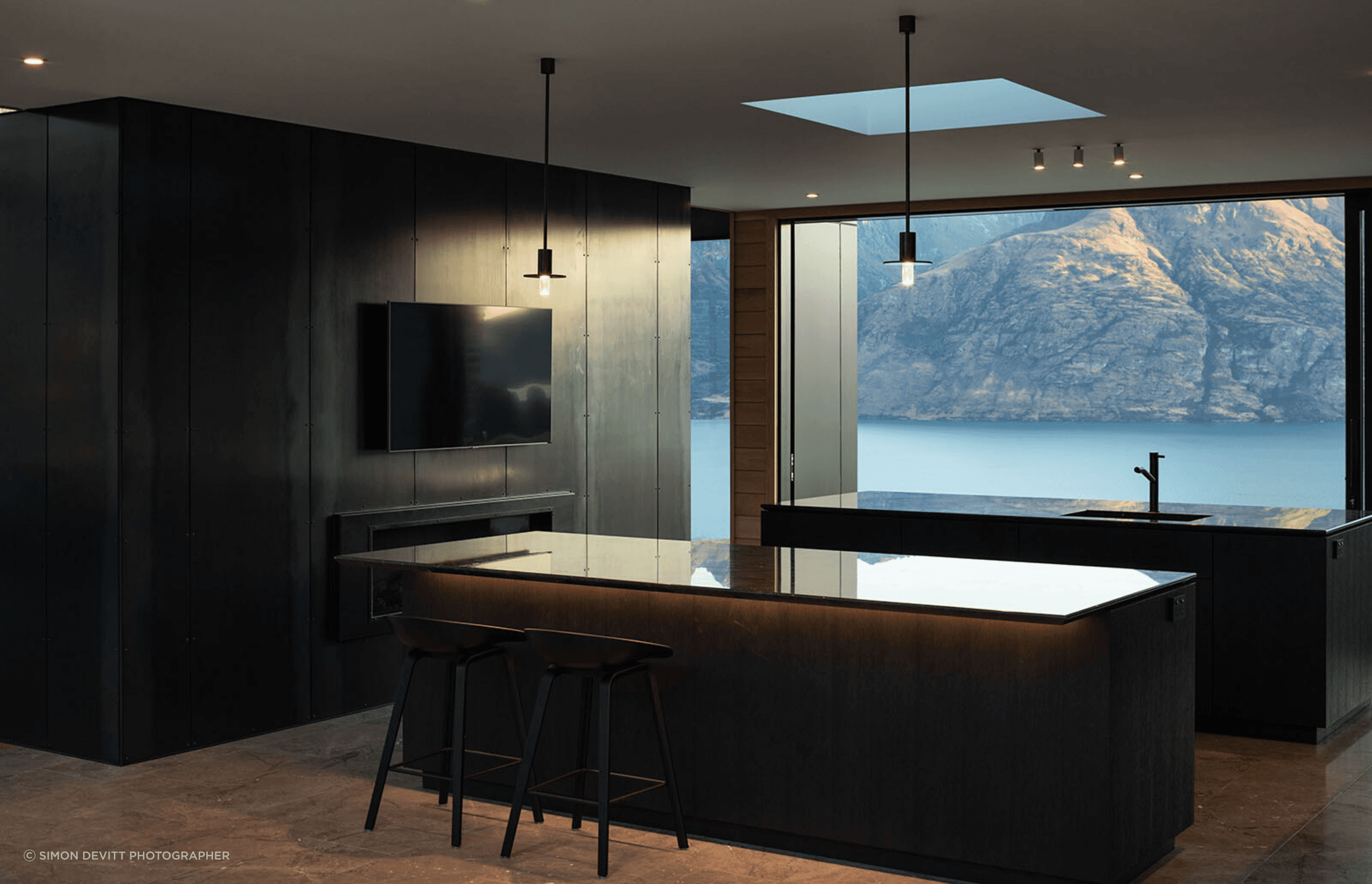 On either side of the kitchen are glass sliders that feature stunning views of the lake on one side, and the mountains on the other.