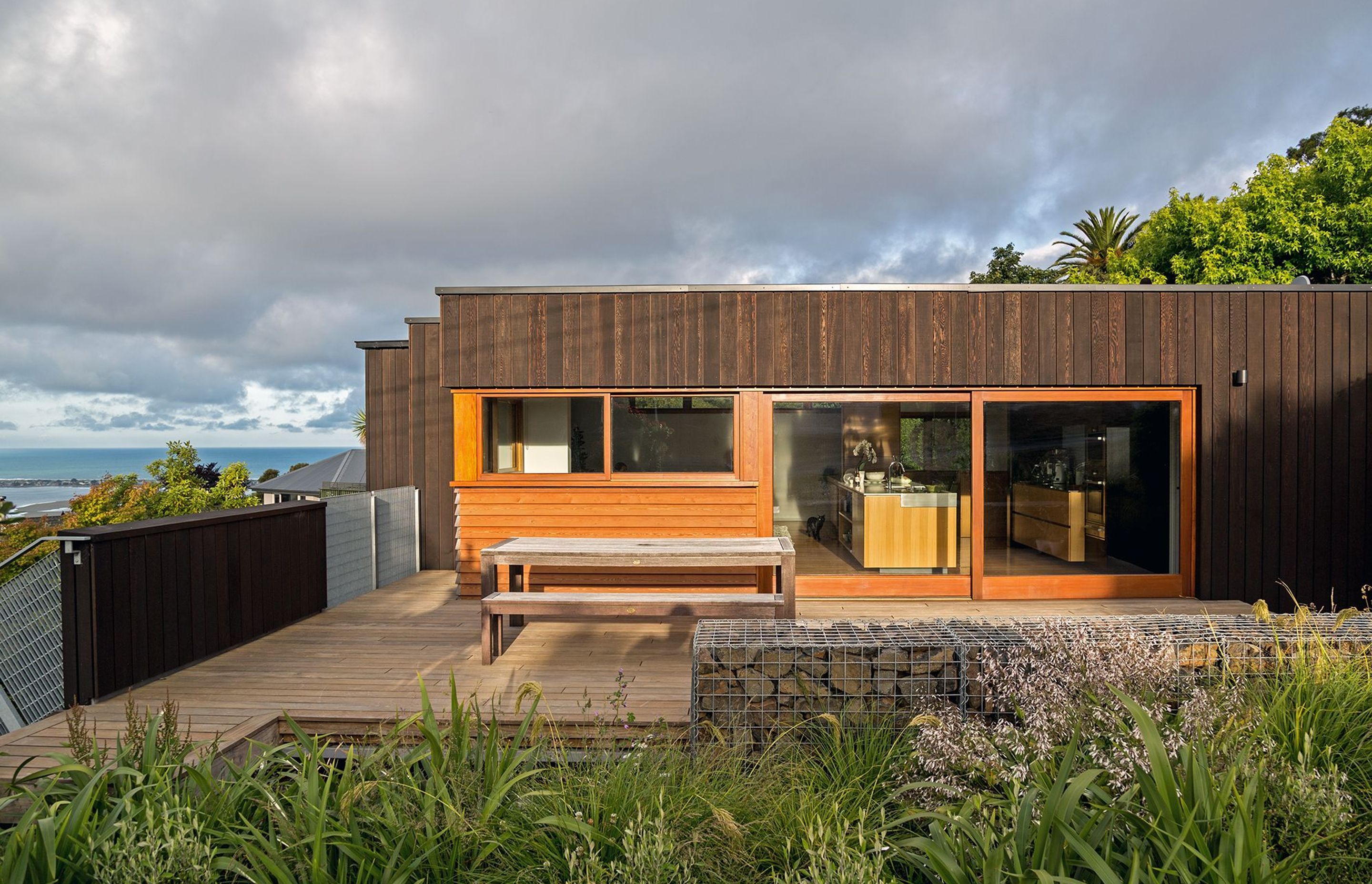 A large, garapa timber entertaining deck has been added to the north-western facade. Vertical cedar shiplap and larch weatherboards were specified for the cladding. Image copyright Russell Kleyn Photographs.