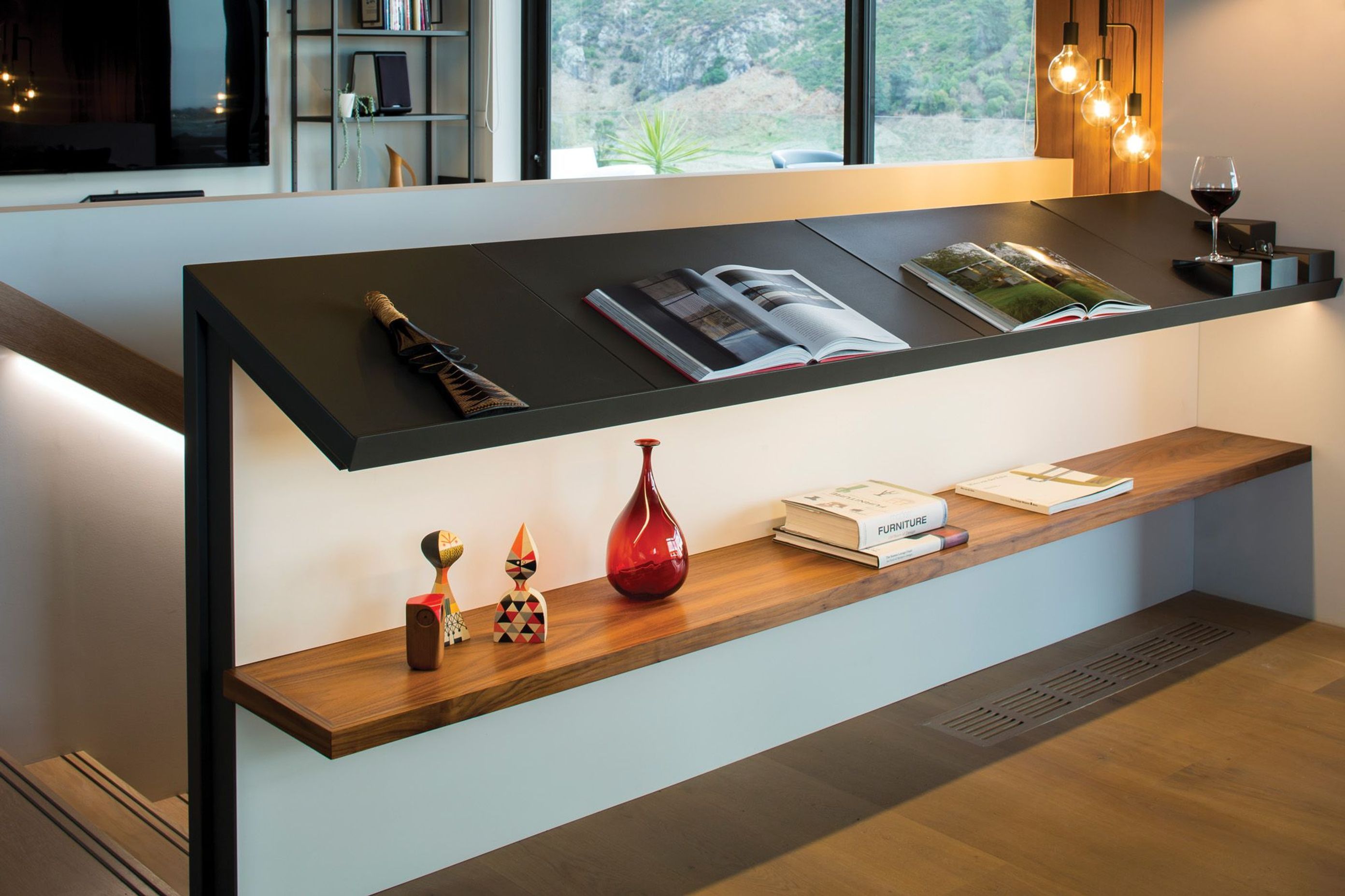 The balustrade on the staircase has built-in metal and timber shelving.