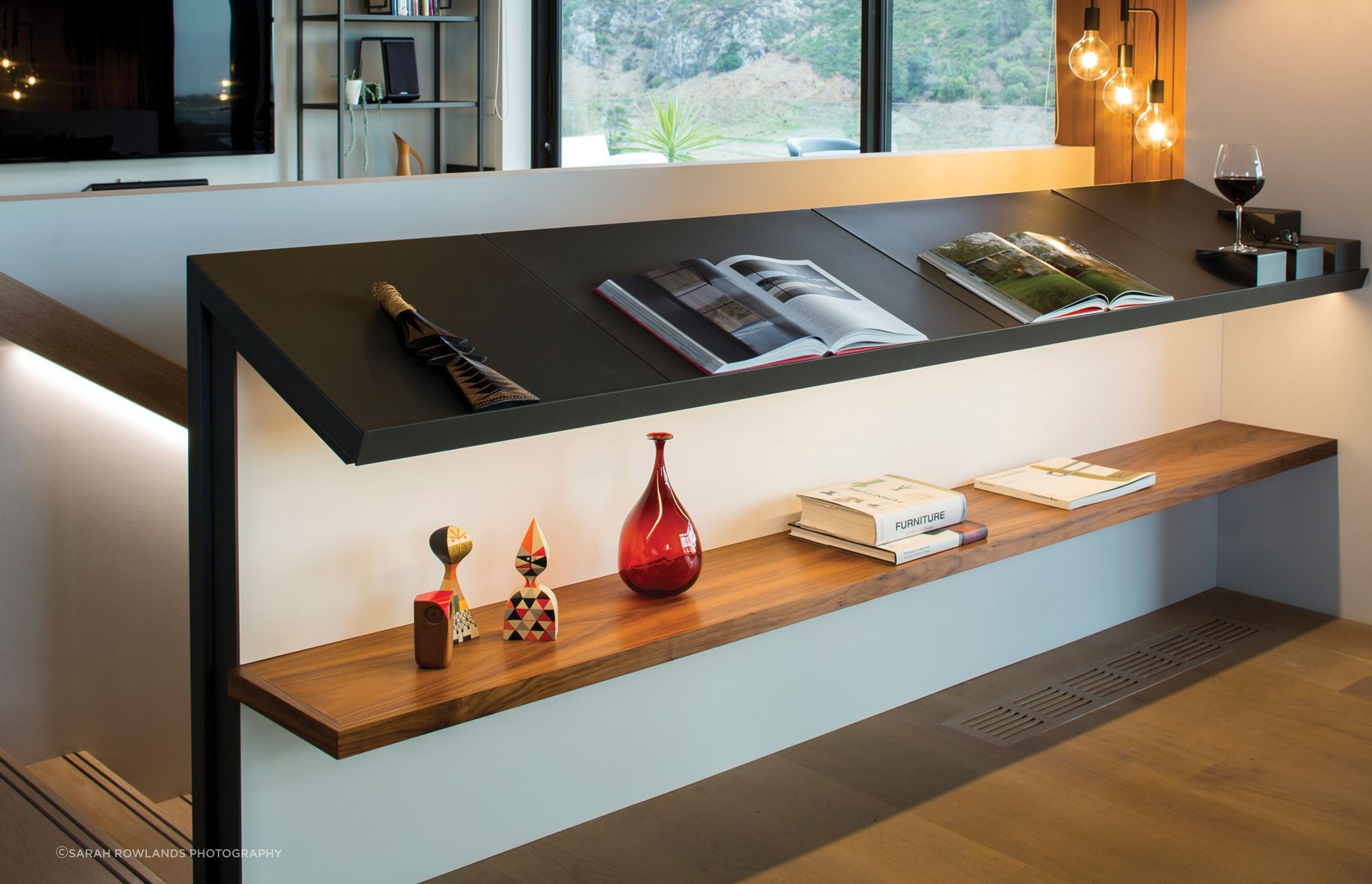 The balustrade on the staircase has built-in metal and timber shelving.