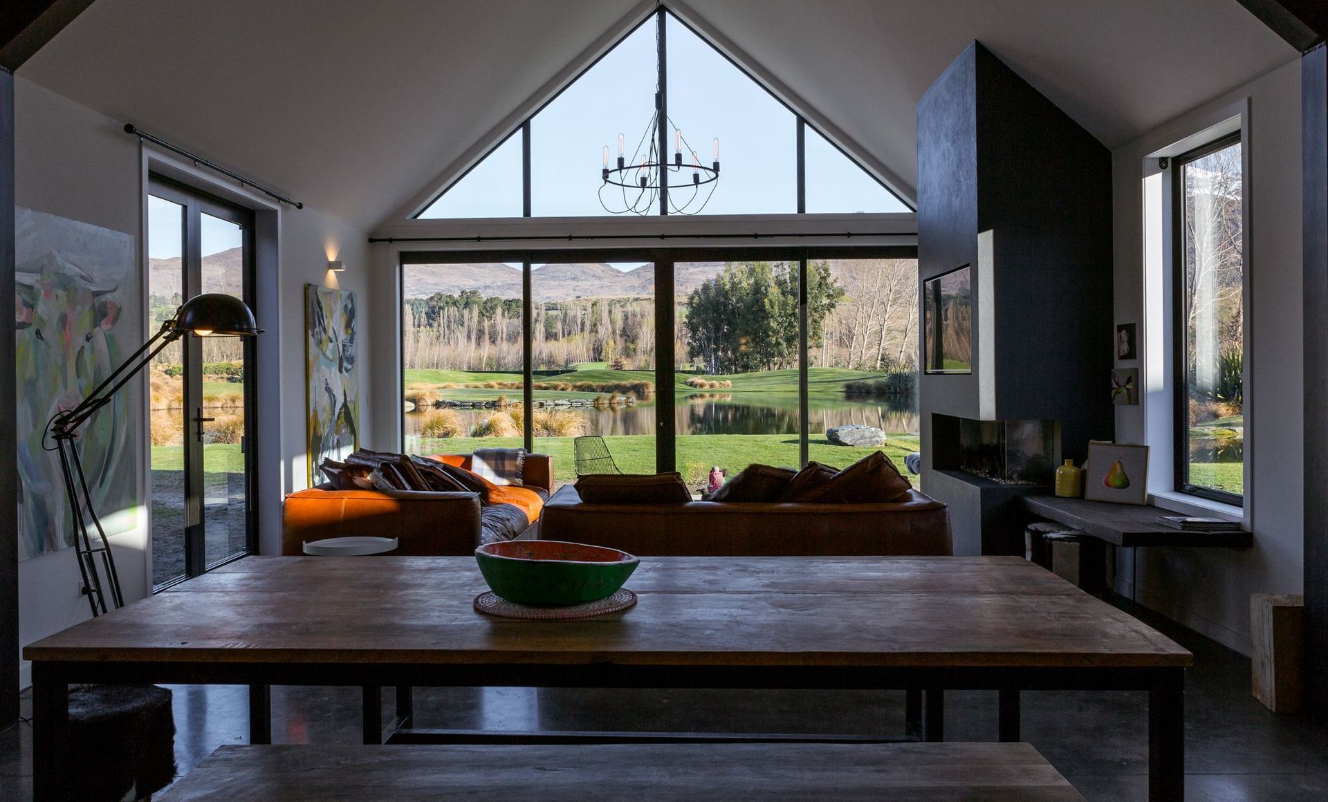 The cathedral ceiling in the open-plan living area gives the space a volumetric presence that references the wide-ranging views through the glazed end wall.