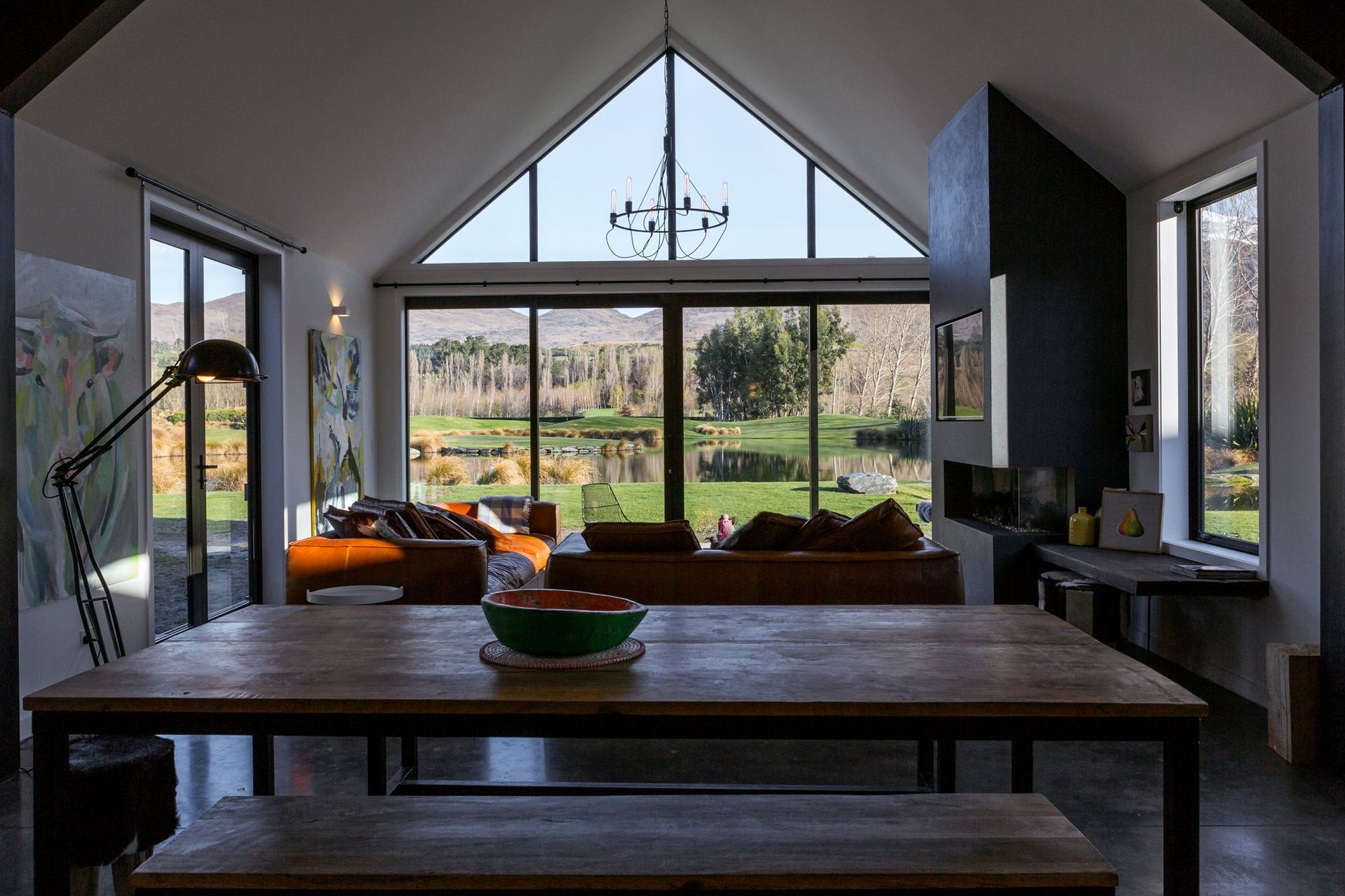 The cathedral ceiling in the open-plan living area gives the space a volumetric presence that references the wide-ranging views through the glazed end wall.