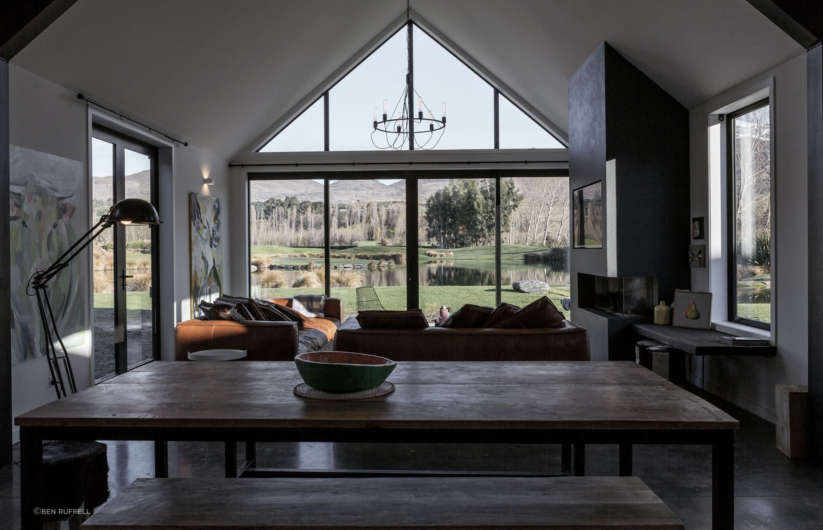 The cathedral ceiling in the open-plan living area gives the space a volumetric presence that references the wide-ranging views through the glazed end wall.