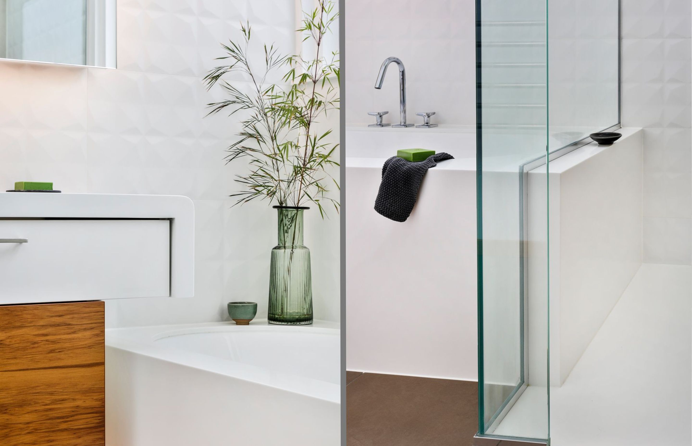 Corian features on the floating vanity top which appears to fall off into the bath surround yet is intentionally separate to create tension. This bath mould subsequently flows seamlessly through into the shower space creating a useful ledge within.
