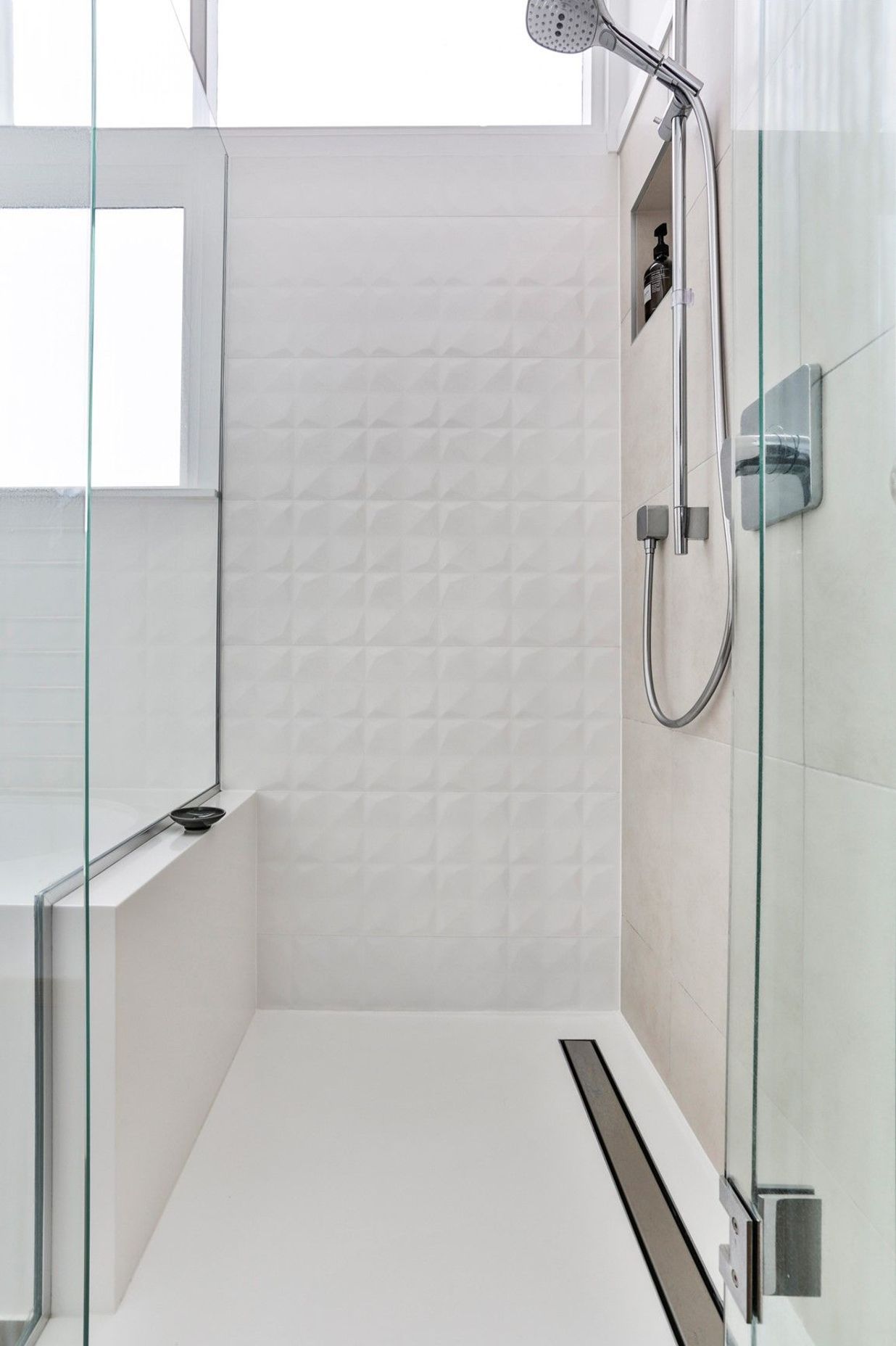 The stream-lined junction between the shower and the bath create the striking monolithic design and delight the owner with its effortless cleaning. 