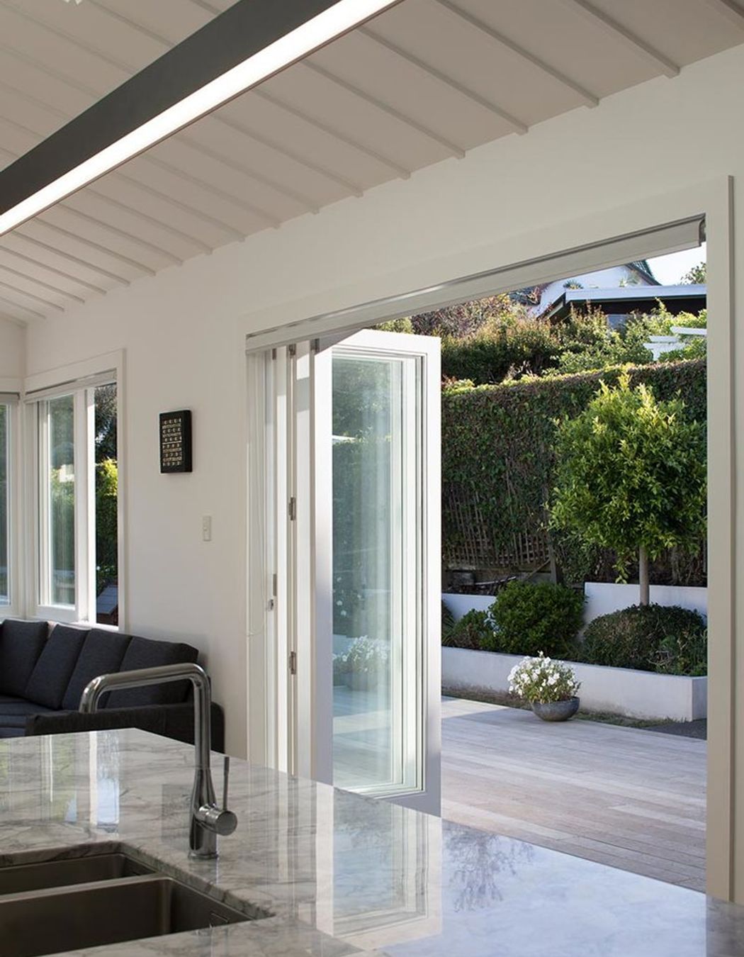 Contemporary bi-fold doors compliment the existing traditional rooflines and open the house to the courtyard.