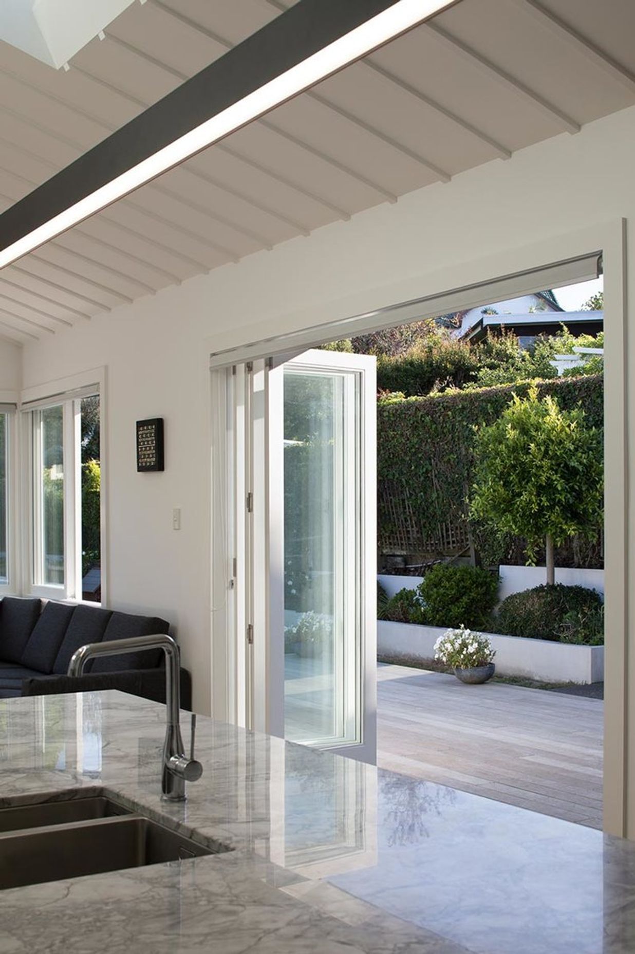 Contemporary bi-fold doors compliment the existing traditional rooflines and open the house to the courtyard.
