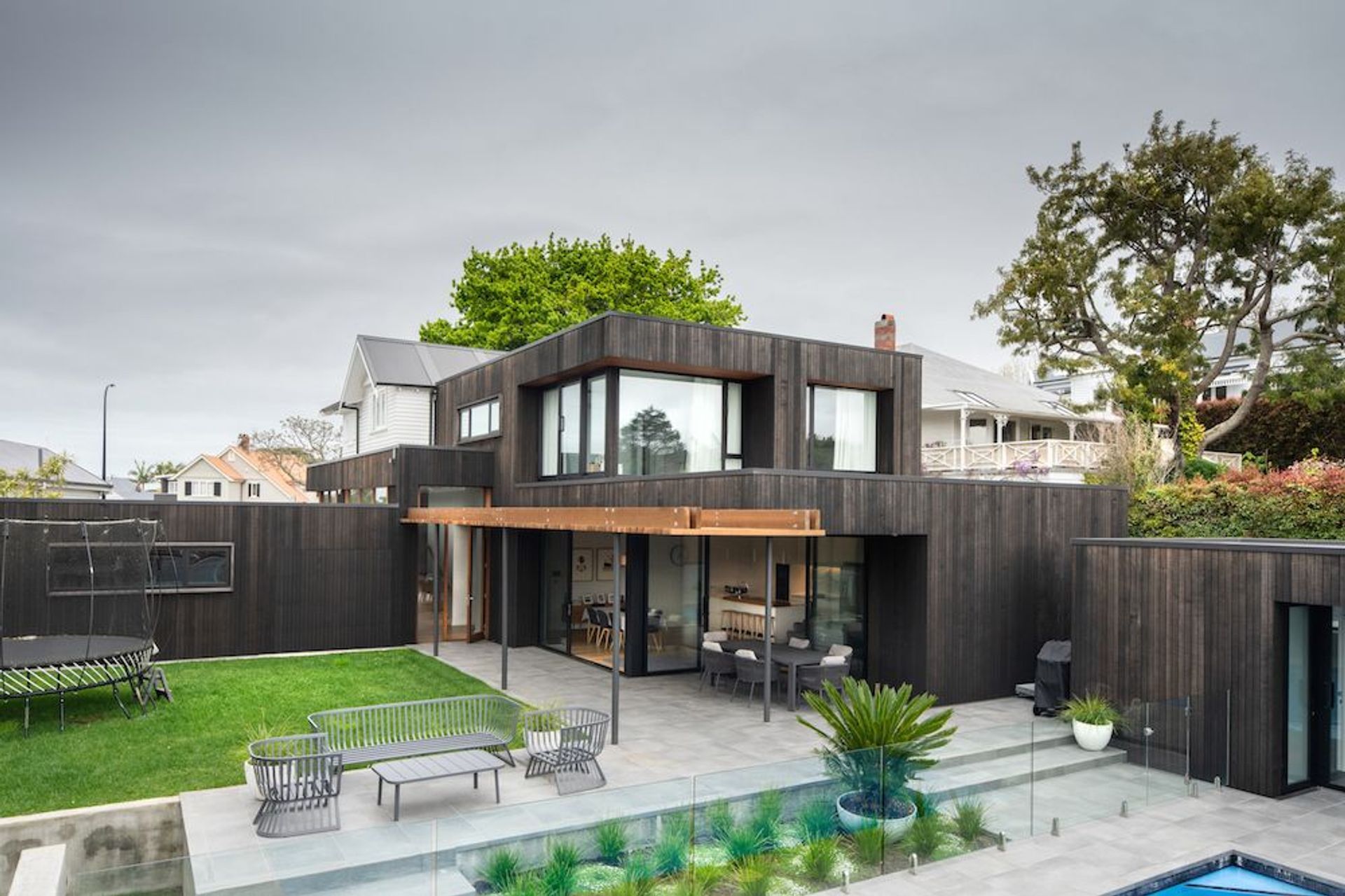The addition to this bungalow is in the form of five 'boxes' clad in dark, vertical cedar that wrap around and connect with the horizontal weatherboards of the original home.