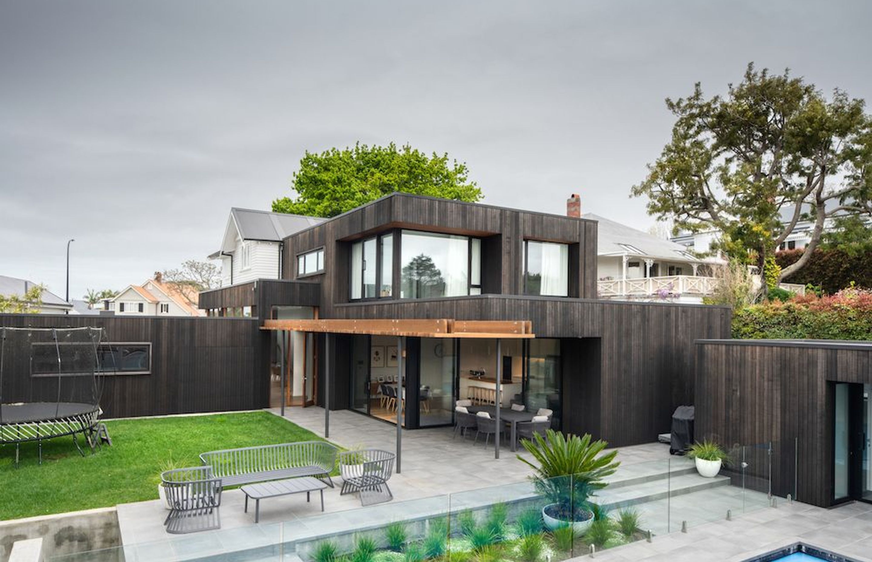 The addition to this bungalow is in the form of five 'boxes' clad in dark, vertical cedar that wrap around and connect with the horizontal weatherboards of the original home. 