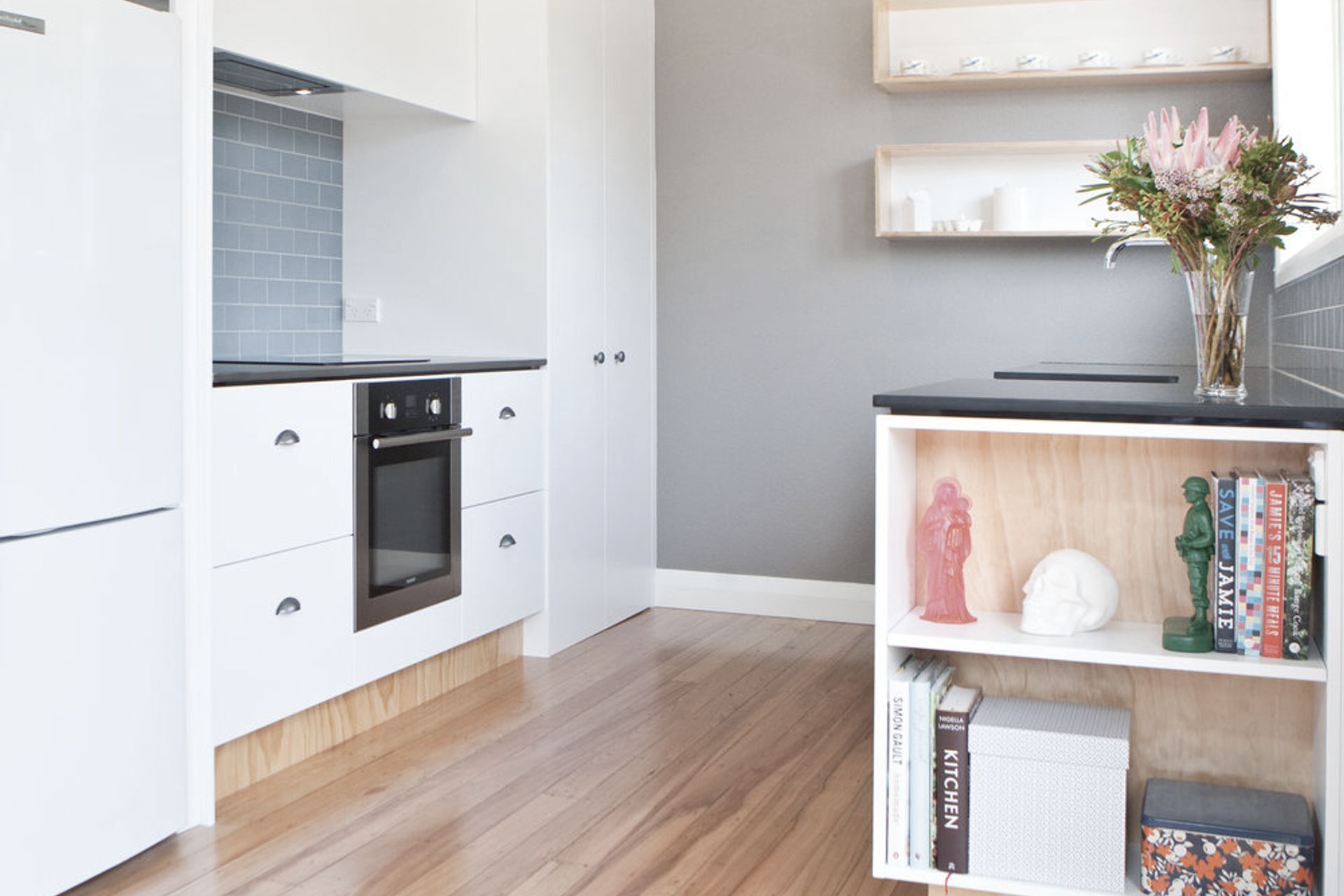 Book storage at the end of the kitchen bench is a good use of space.