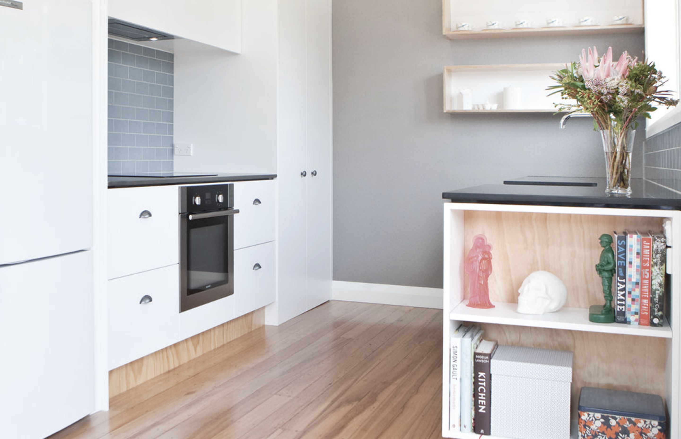 Book storage at the end of the kitchen bench is a good use of space.